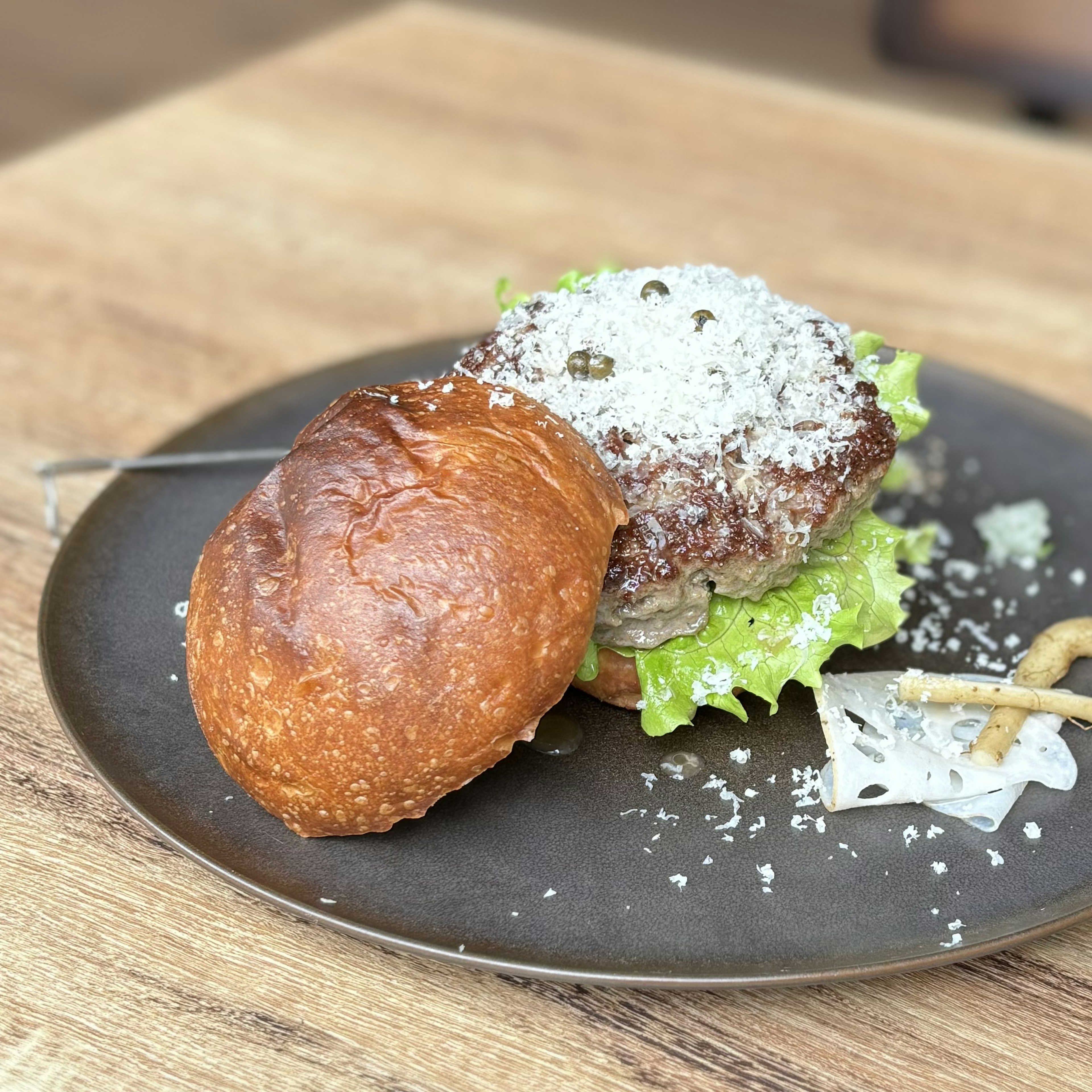 美味しそうなハンバーガーとレタスの上にチーズがトッピングされたプレート