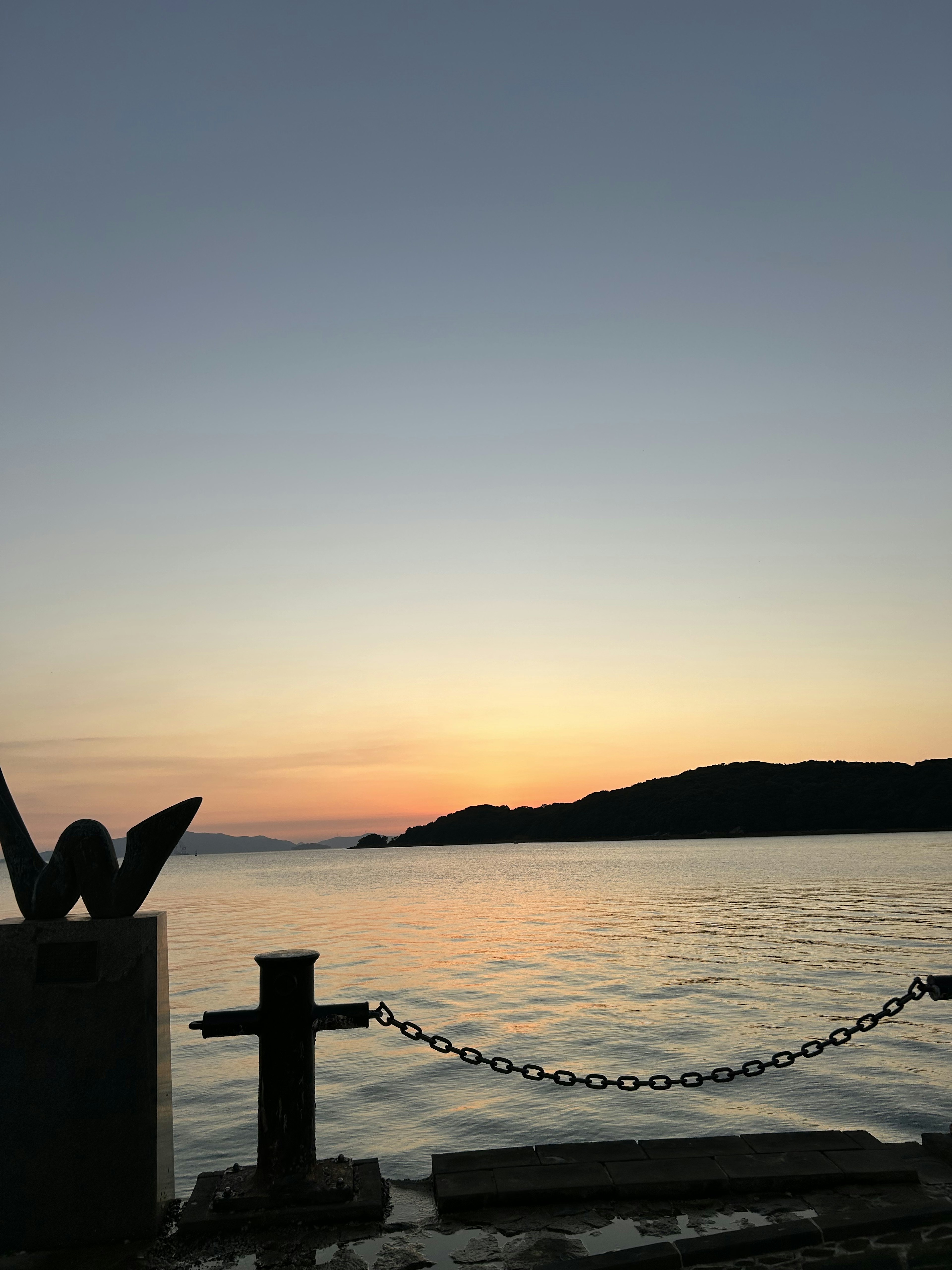 夕焼けの海と島のシルエットが見える風景