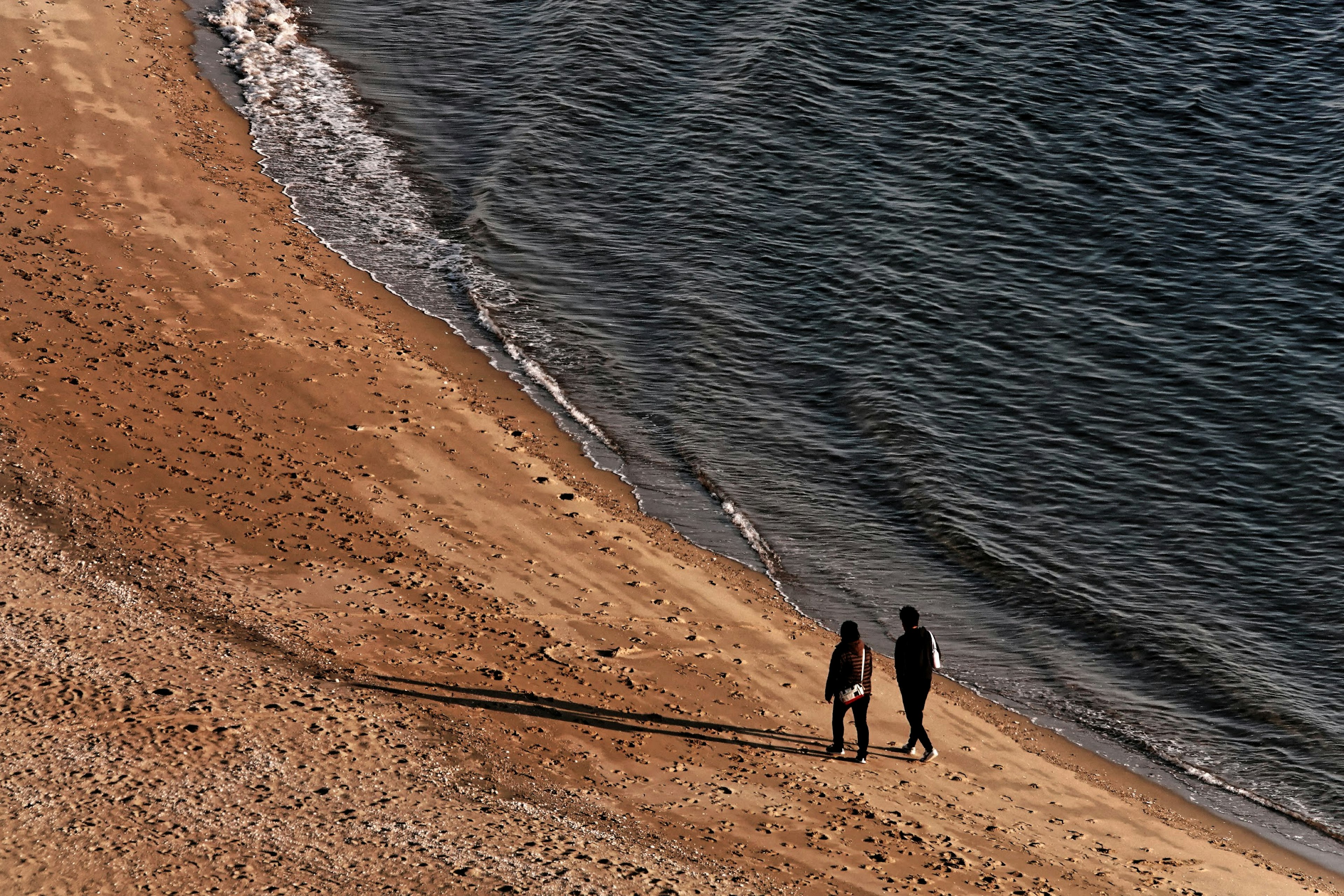 Silhouette d'un couple marchant sur la plage