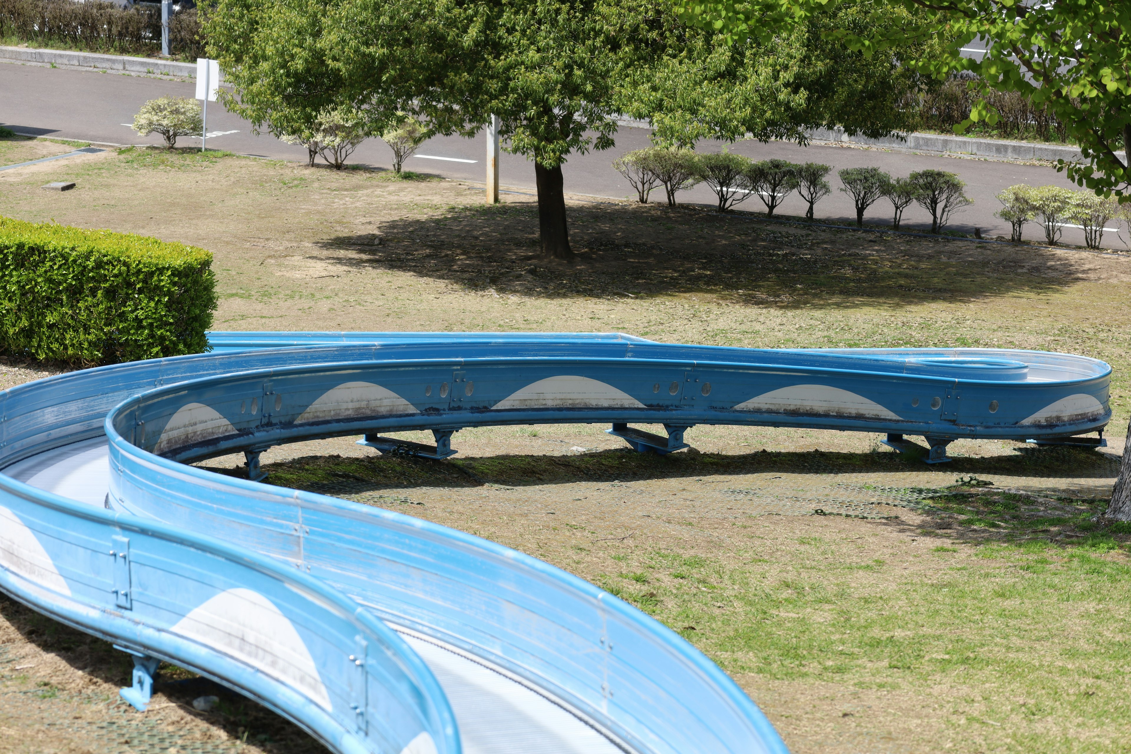 Curved blue slide in a park setting