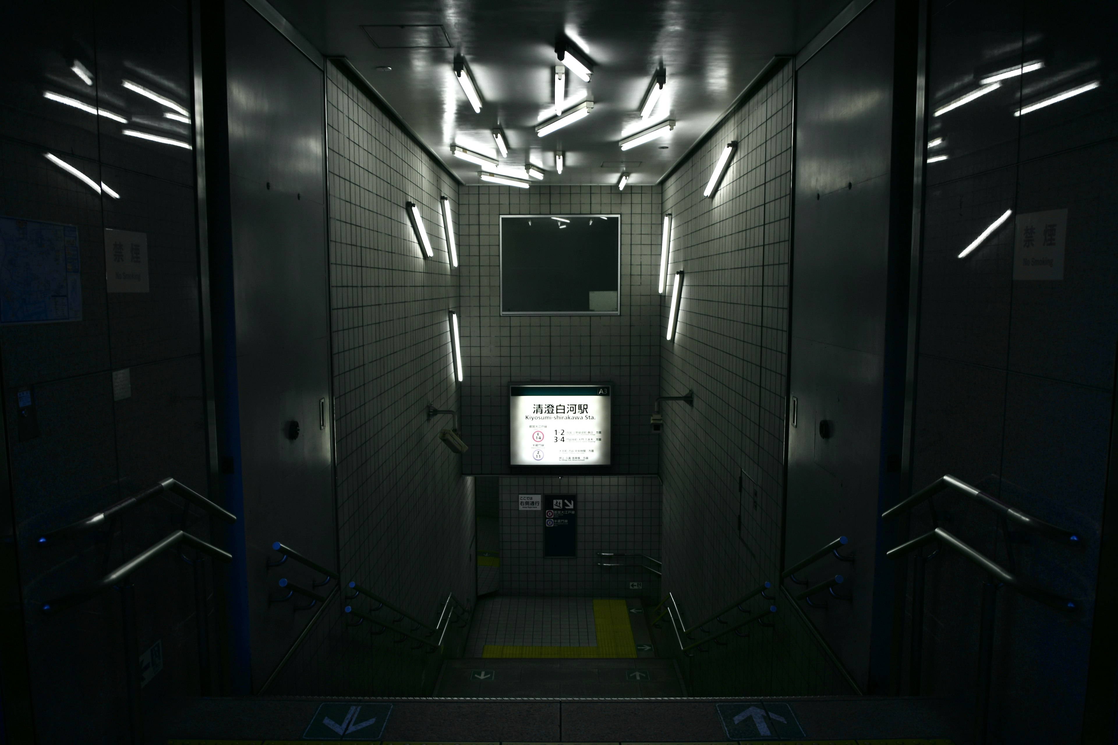 Interior of a dark elevator featuring bright lighting and a monitor