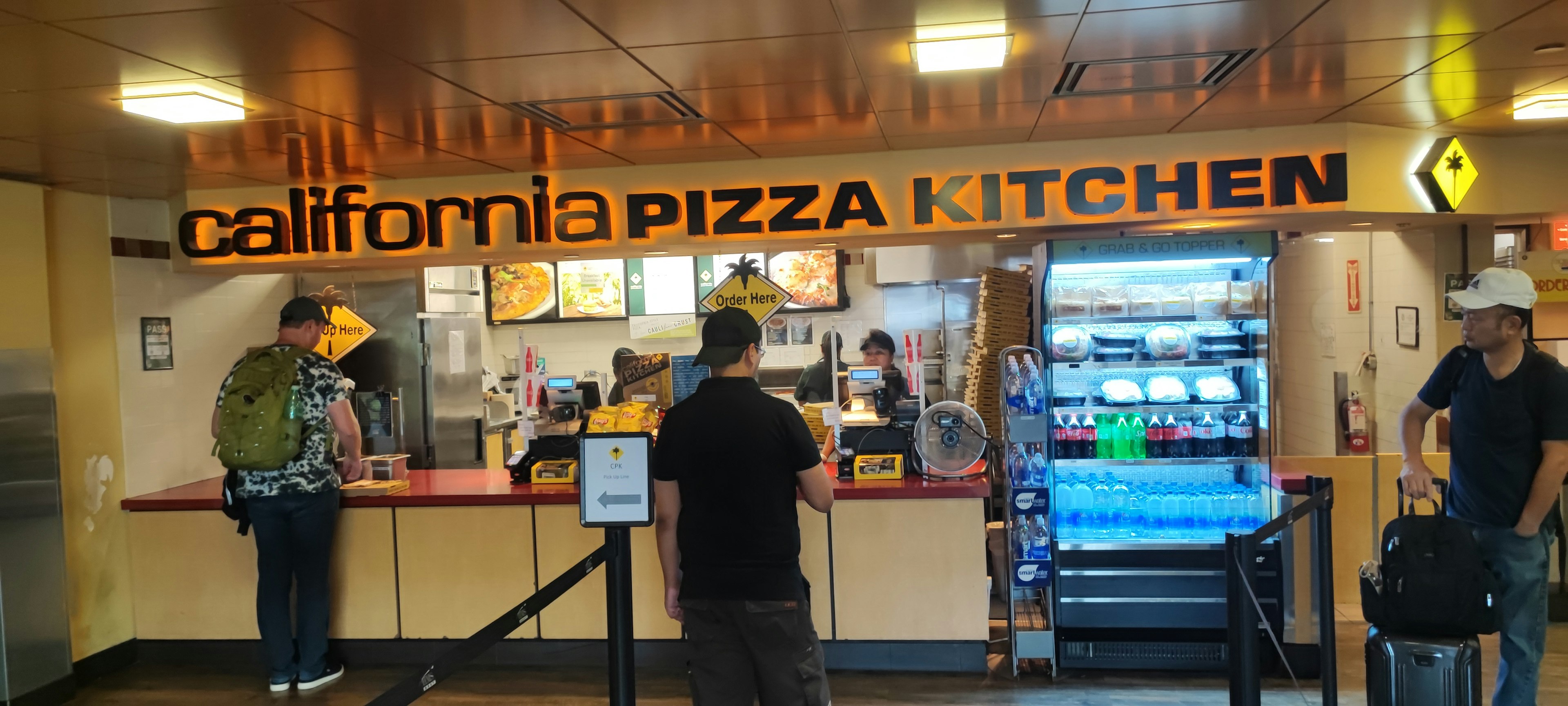 Customers ordering at California Pizza Kitchen counter