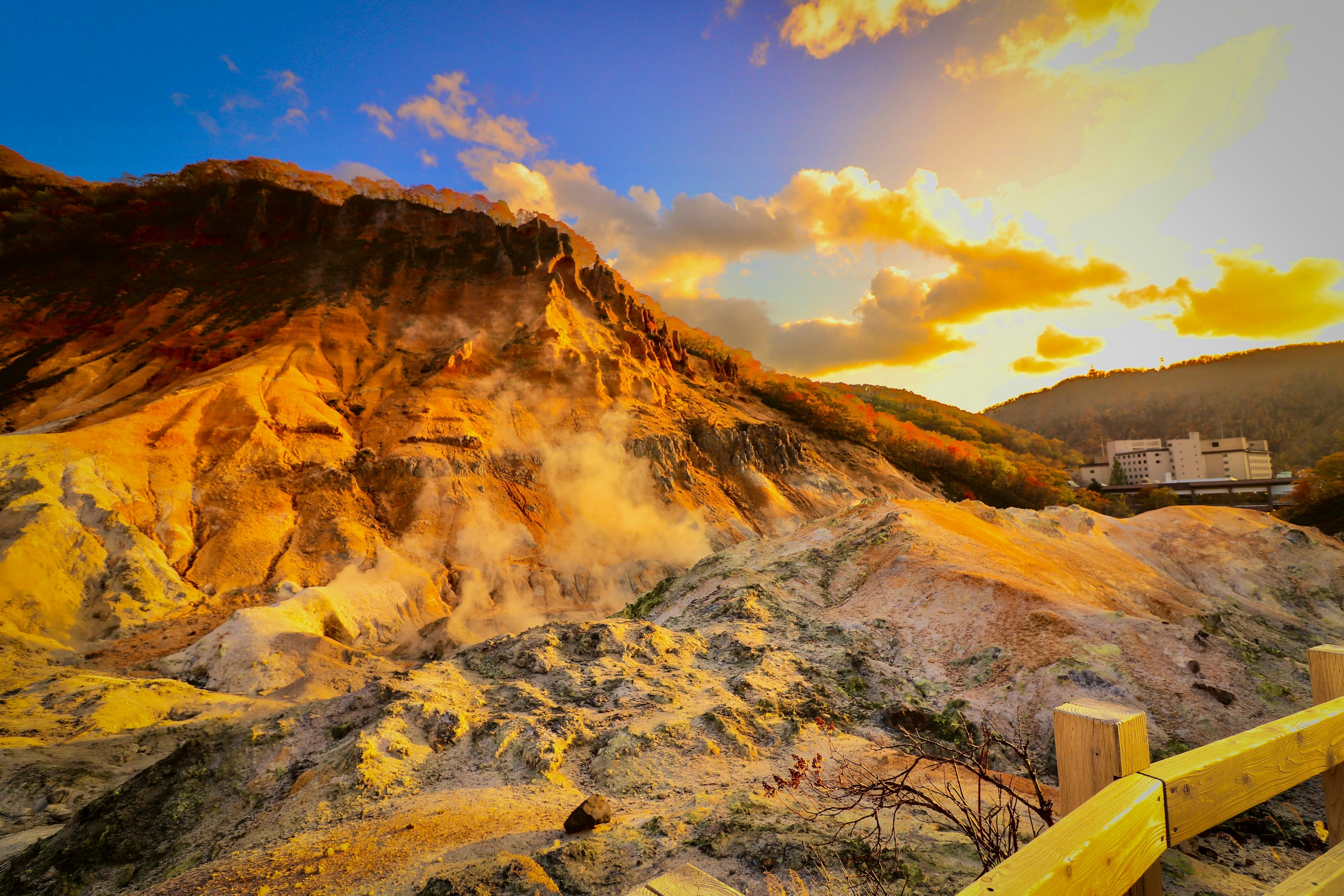 Scenic view of a mountain landscape with steam rising at sunset