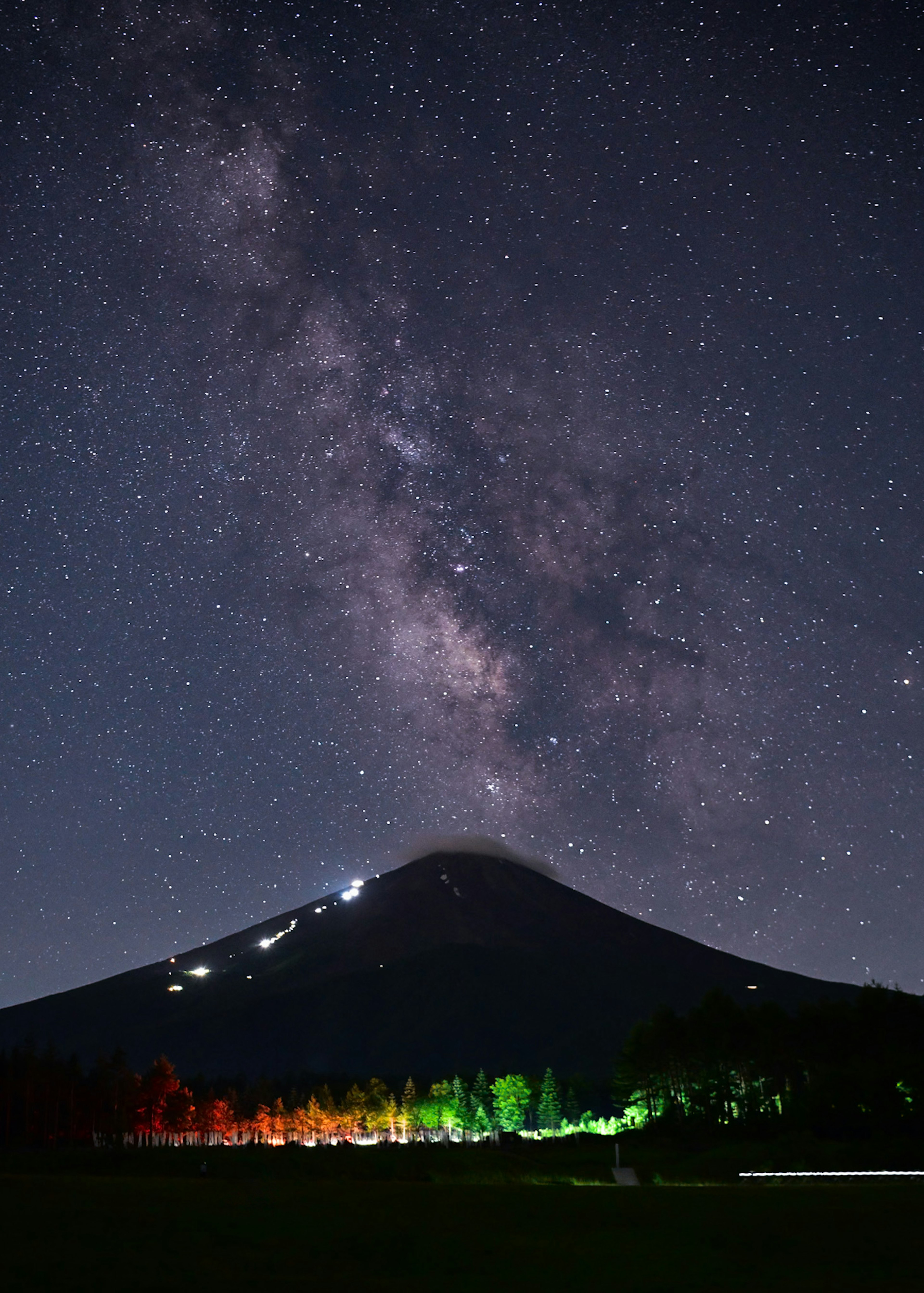 วิวกลางคืนที่สวยงามของภูเขาฟูจิกับท้องฟ้าที่เต็มไปด้วยดวงดาวและทางช้างเผือก