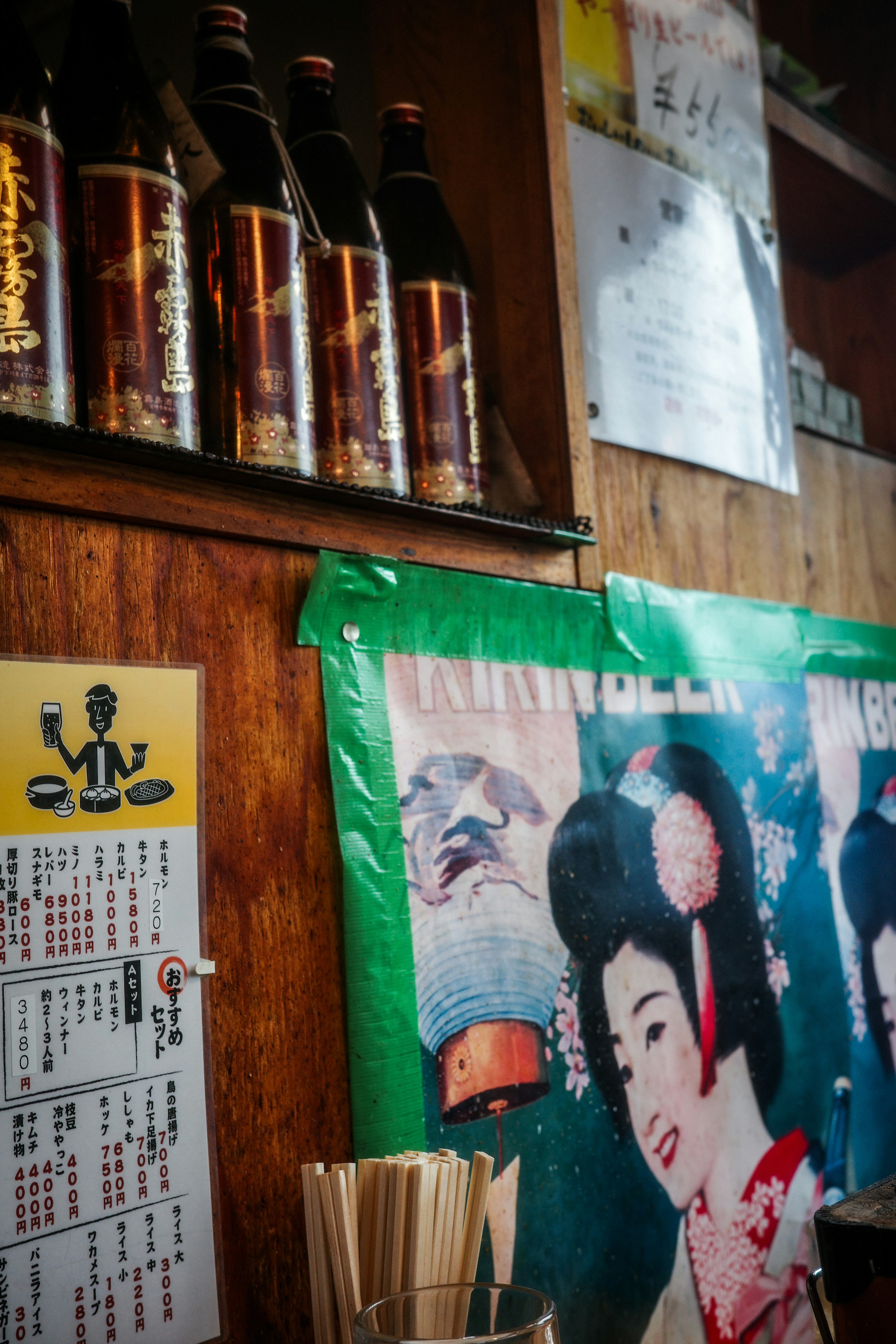 Interior izakaya dengan poster vintage dan botol