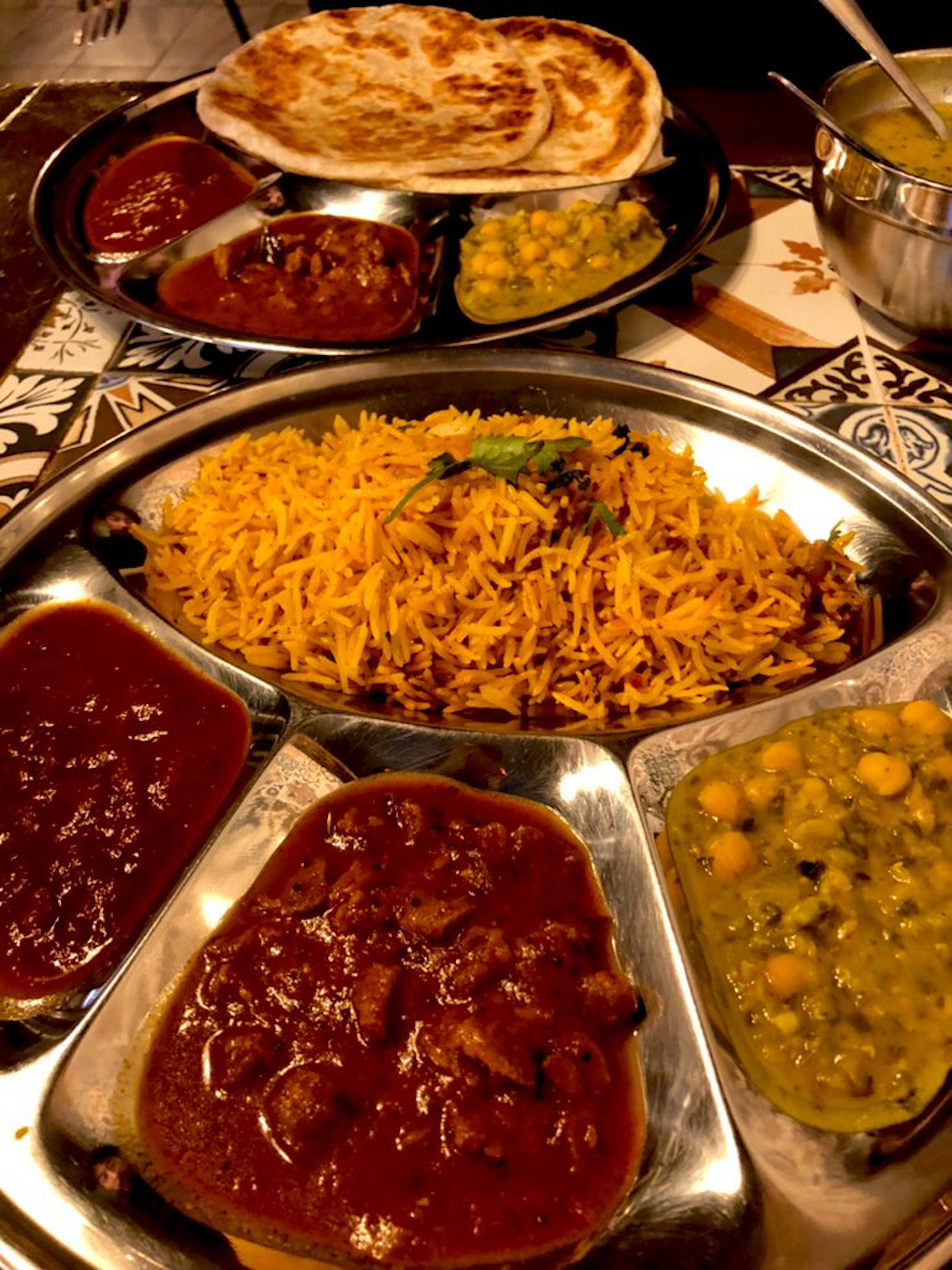 Una bandeja de cocina india con curries coloridos y arroz basmati