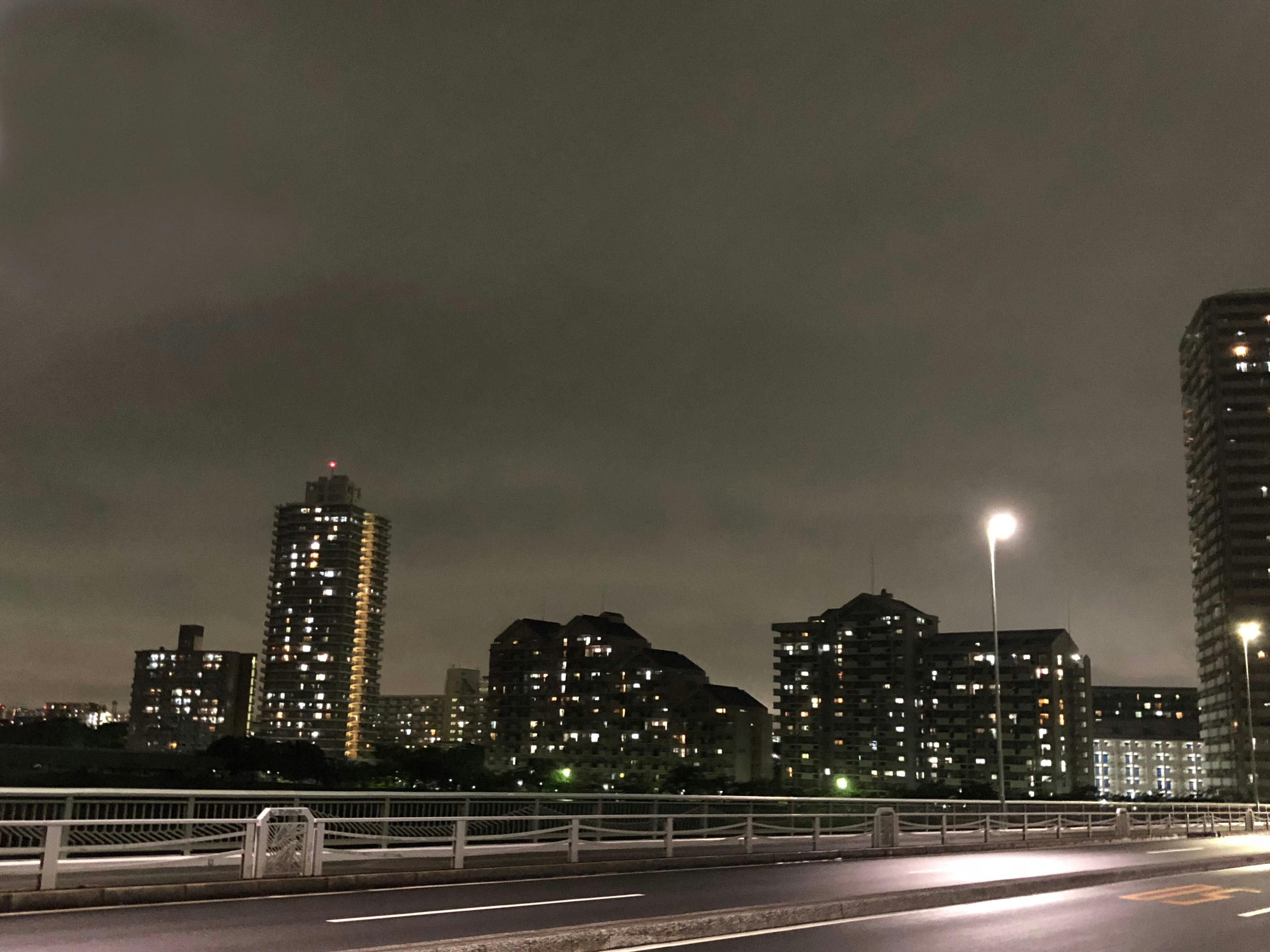 Night cityscape featuring tall buildings and a dark sky