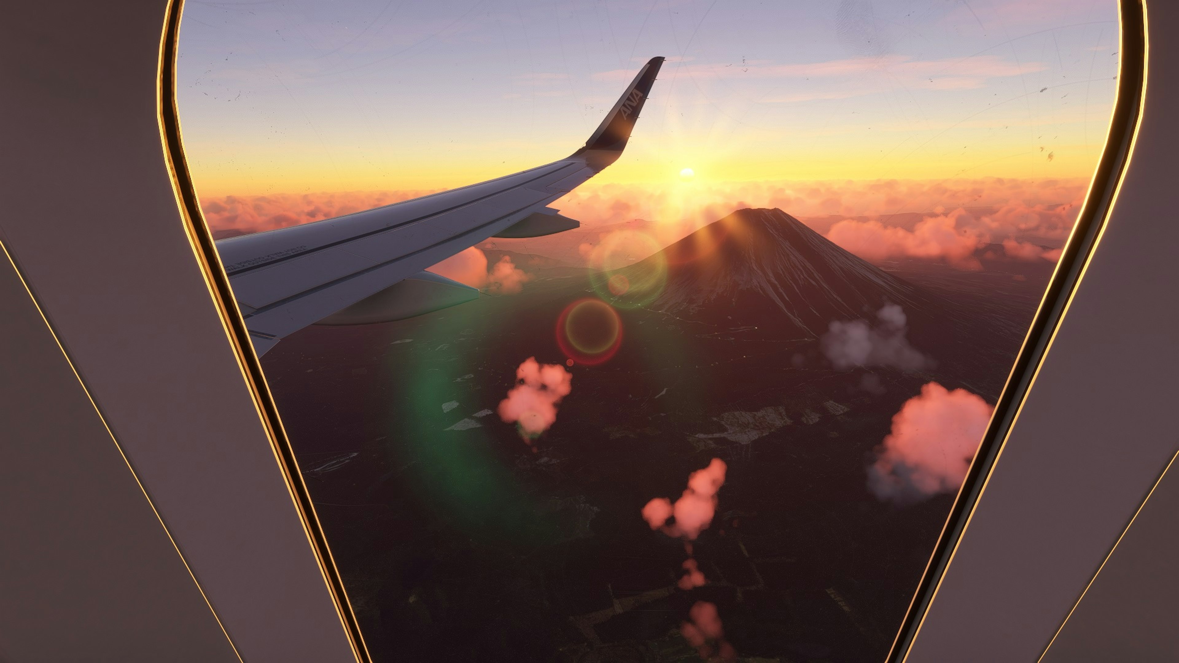 飛行機の窓から見える夕日と山の景色