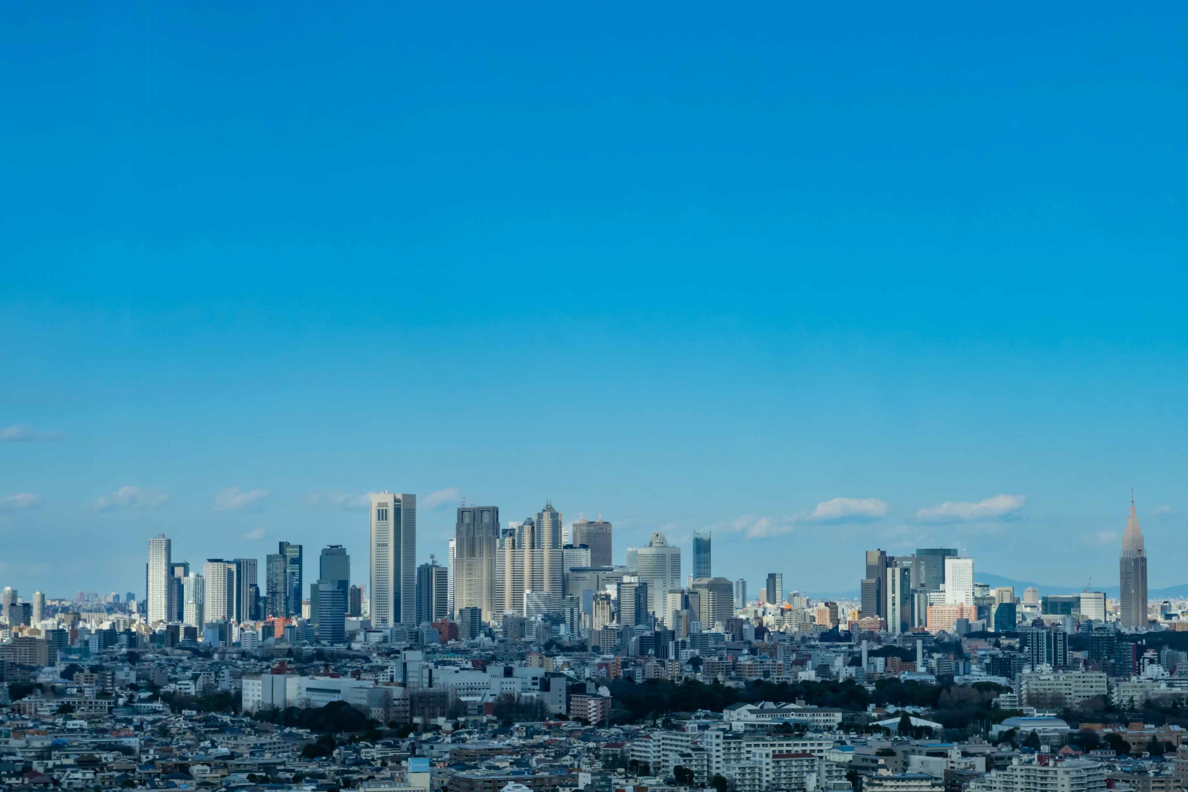 Skyline di Tokyo con grattacieli sotto un cielo azzurro