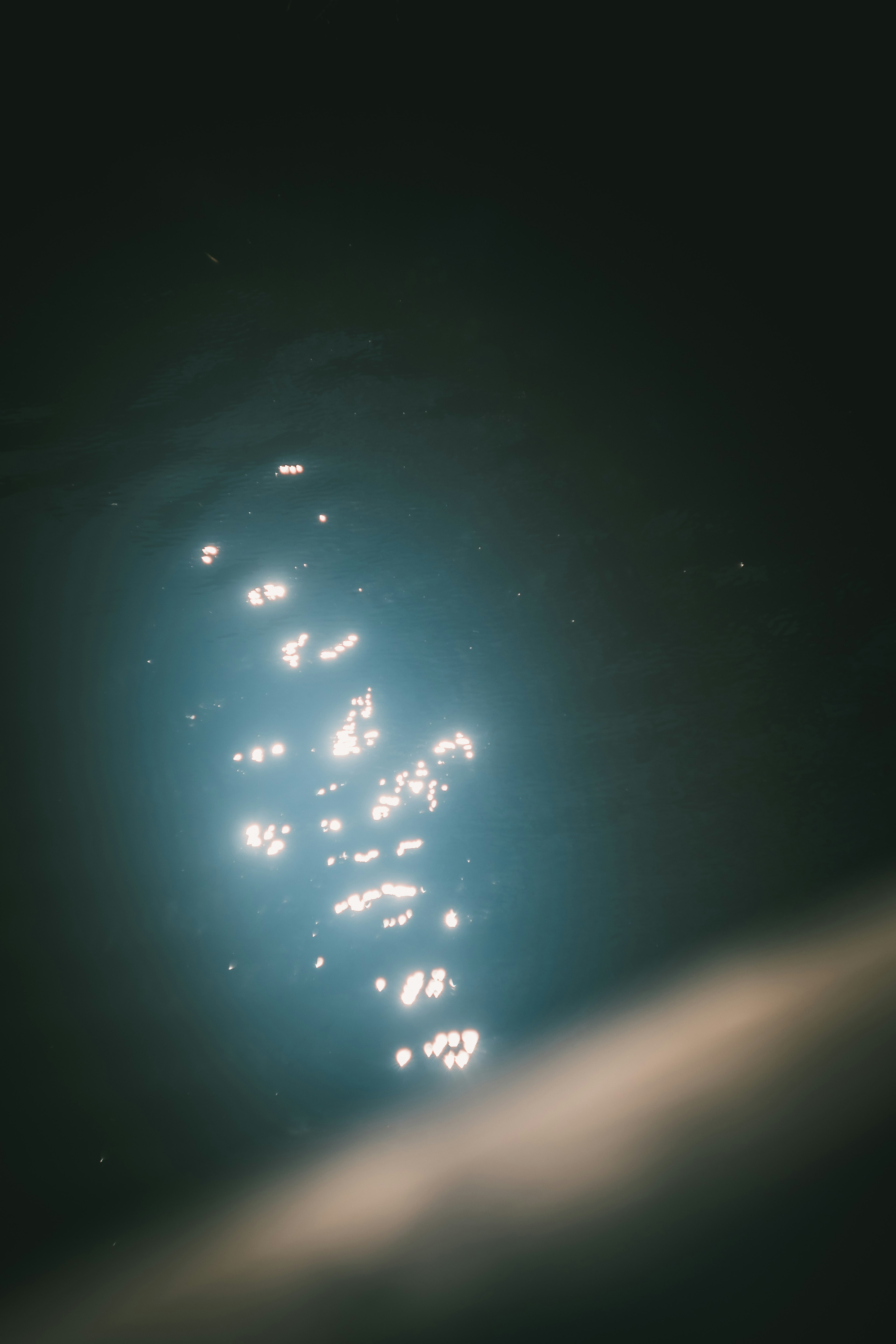 Image of shimmering light reflections on dark water surface