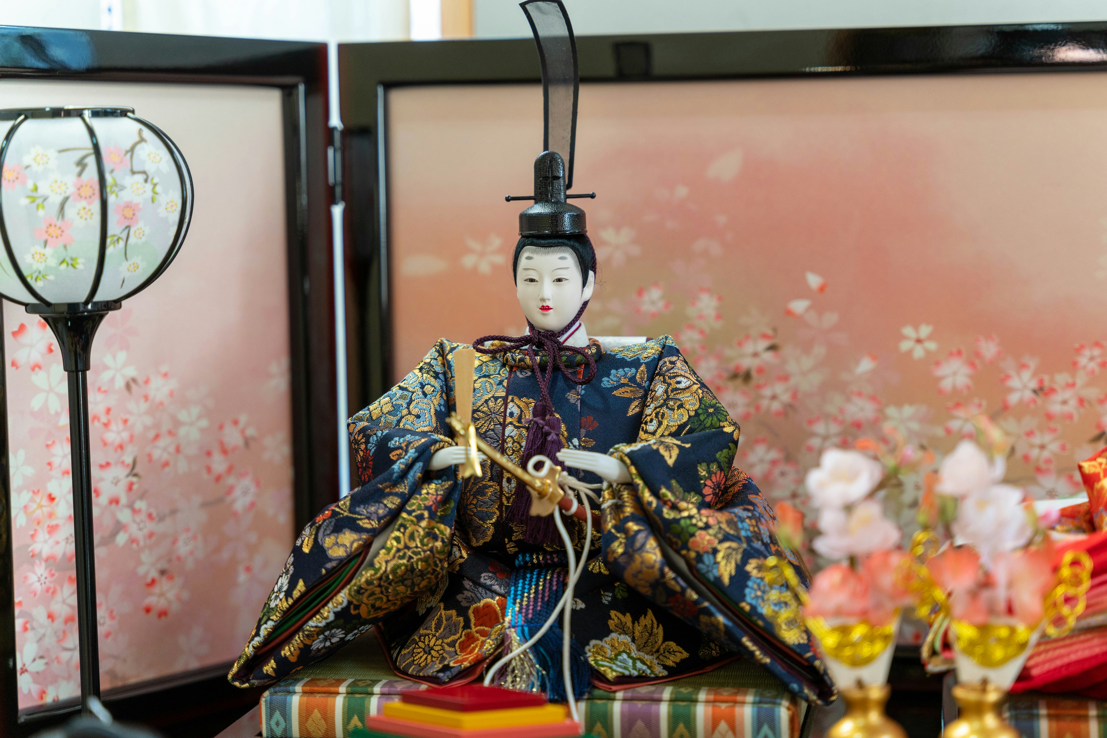 Traditional Japanese hina doll dressed in a beautiful kimono displayed with decorative elements