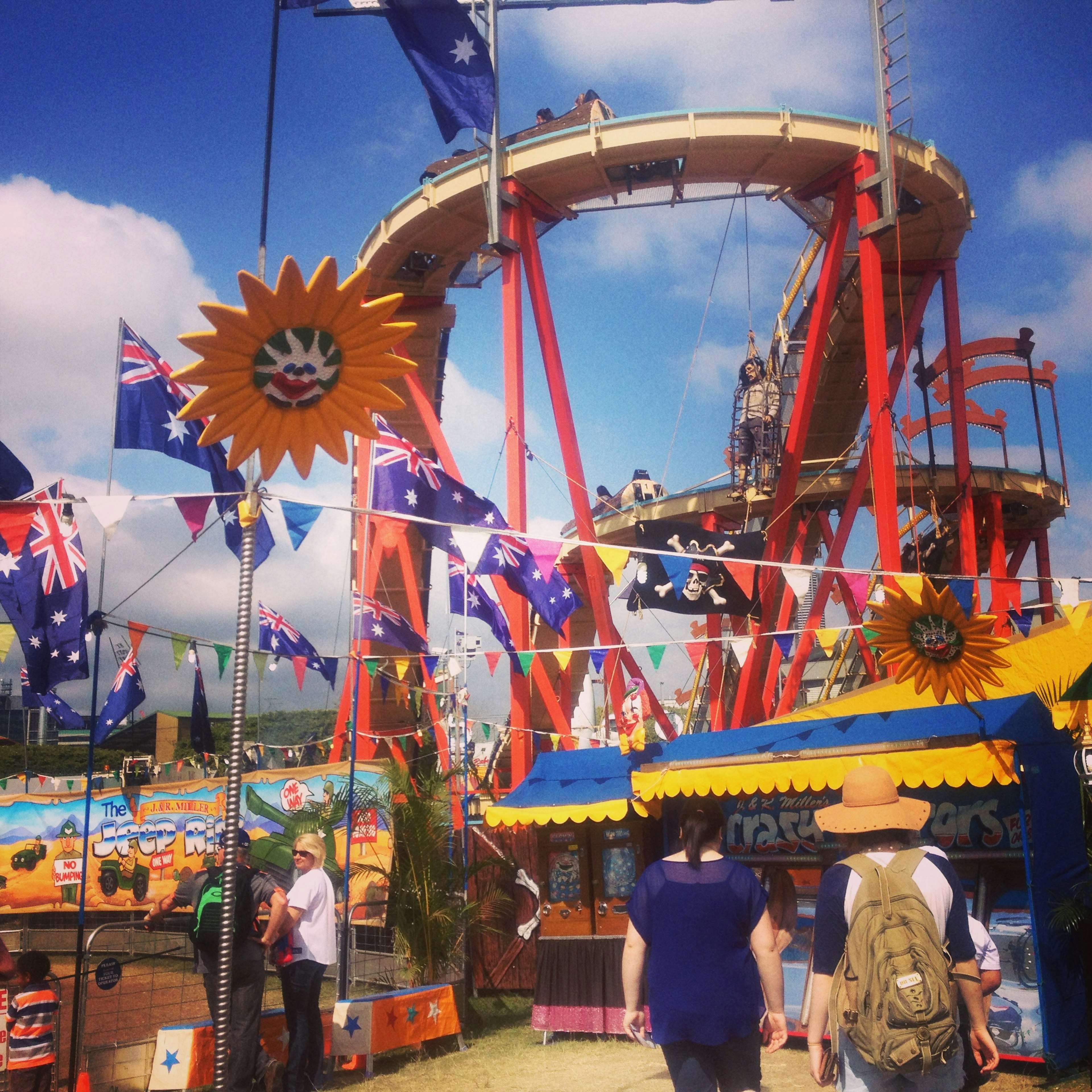 Pemandangan karnaval dengan roller coaster dan bendera Australia tenda berwarna-warni