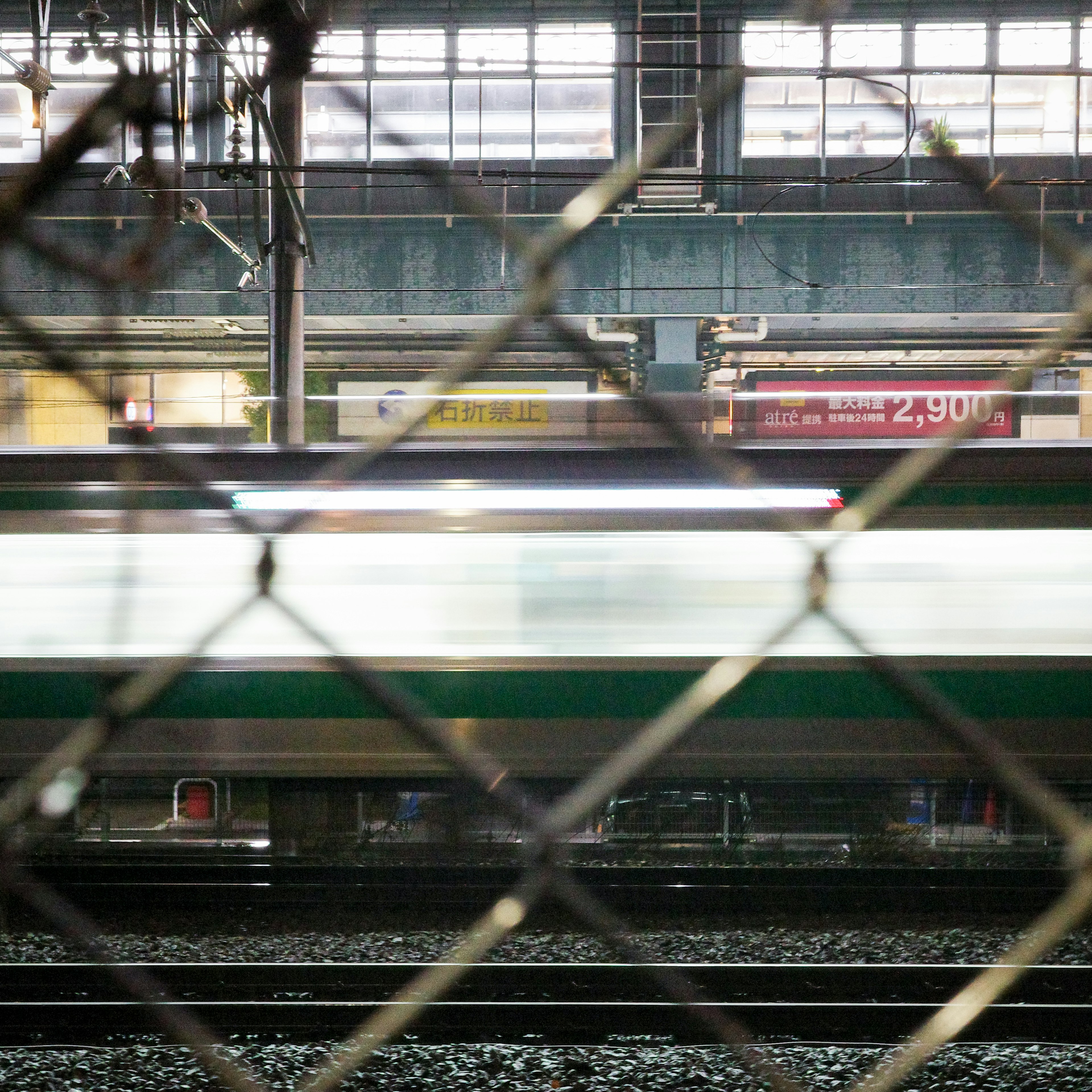 鉄道の駅での列車の流れとフェンスの背景