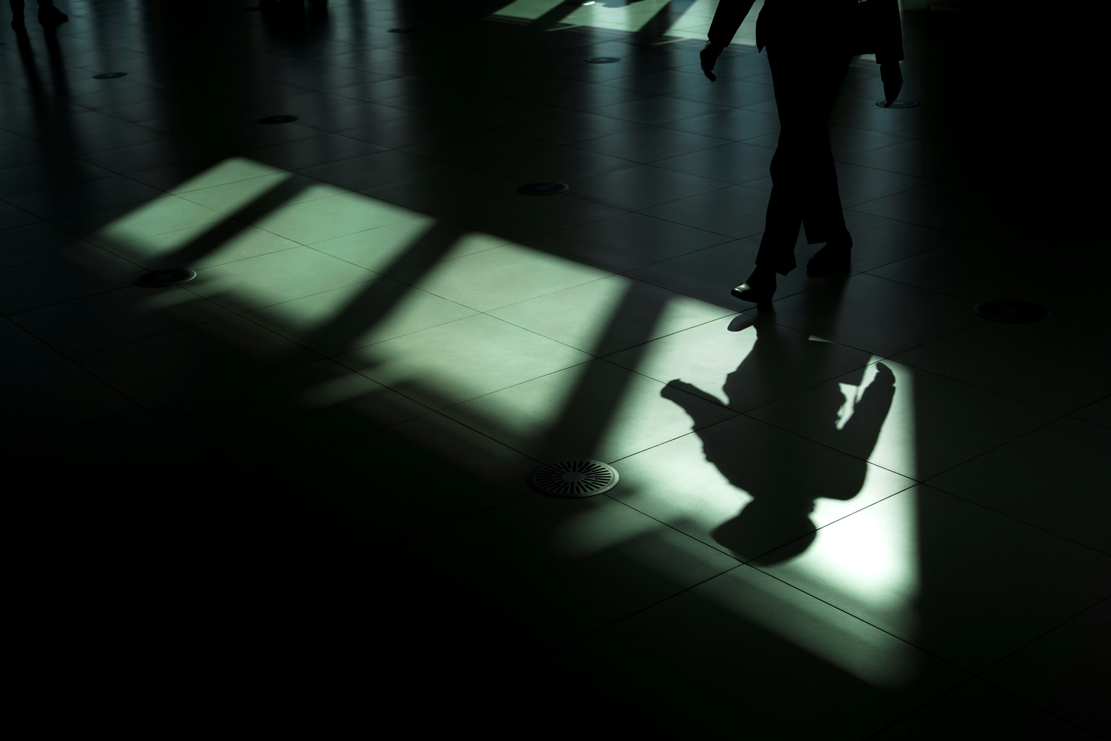 Silhouette of a person walking on a floor with shadows