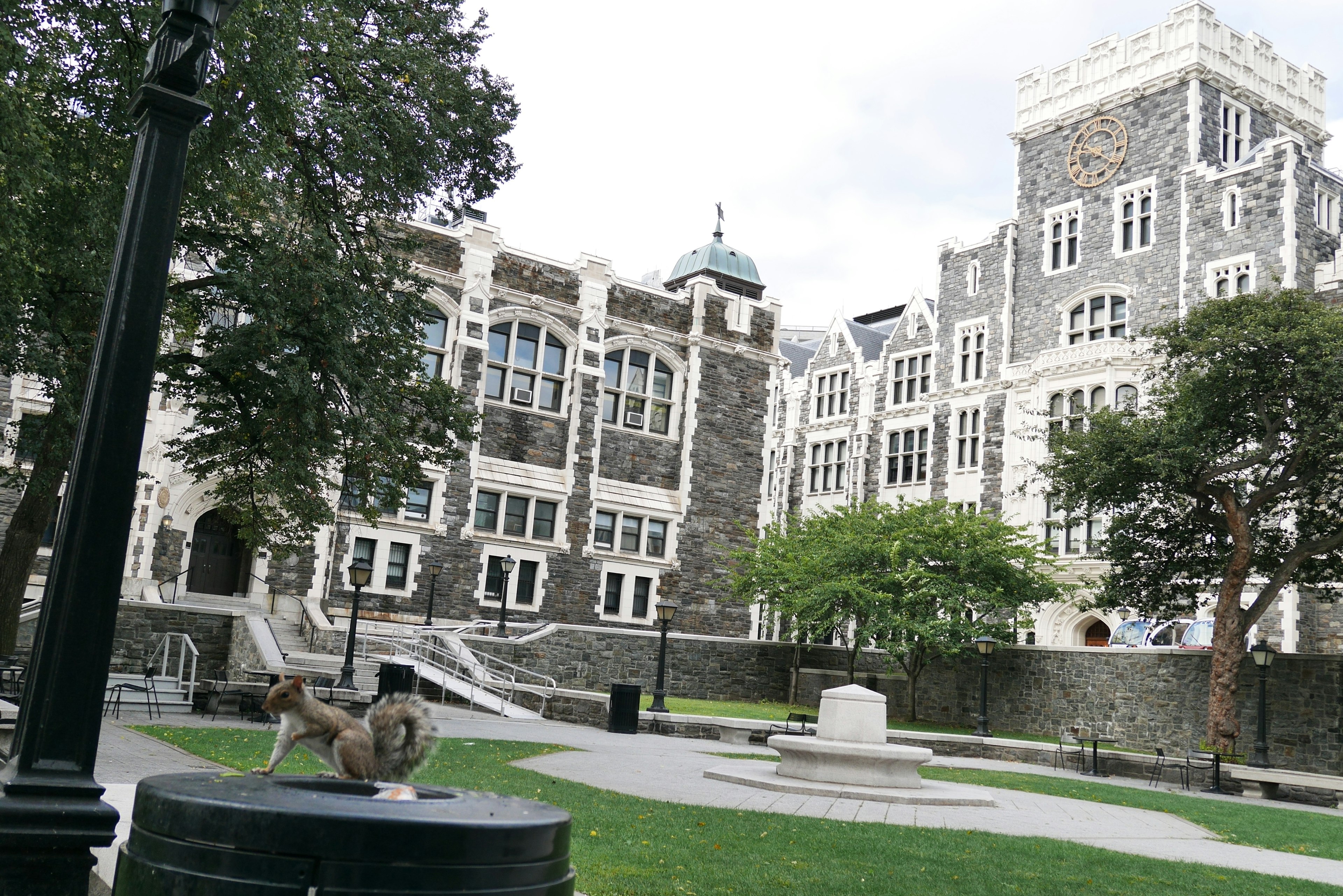 Vista del campus del City College con edificios de piedra y césped verde