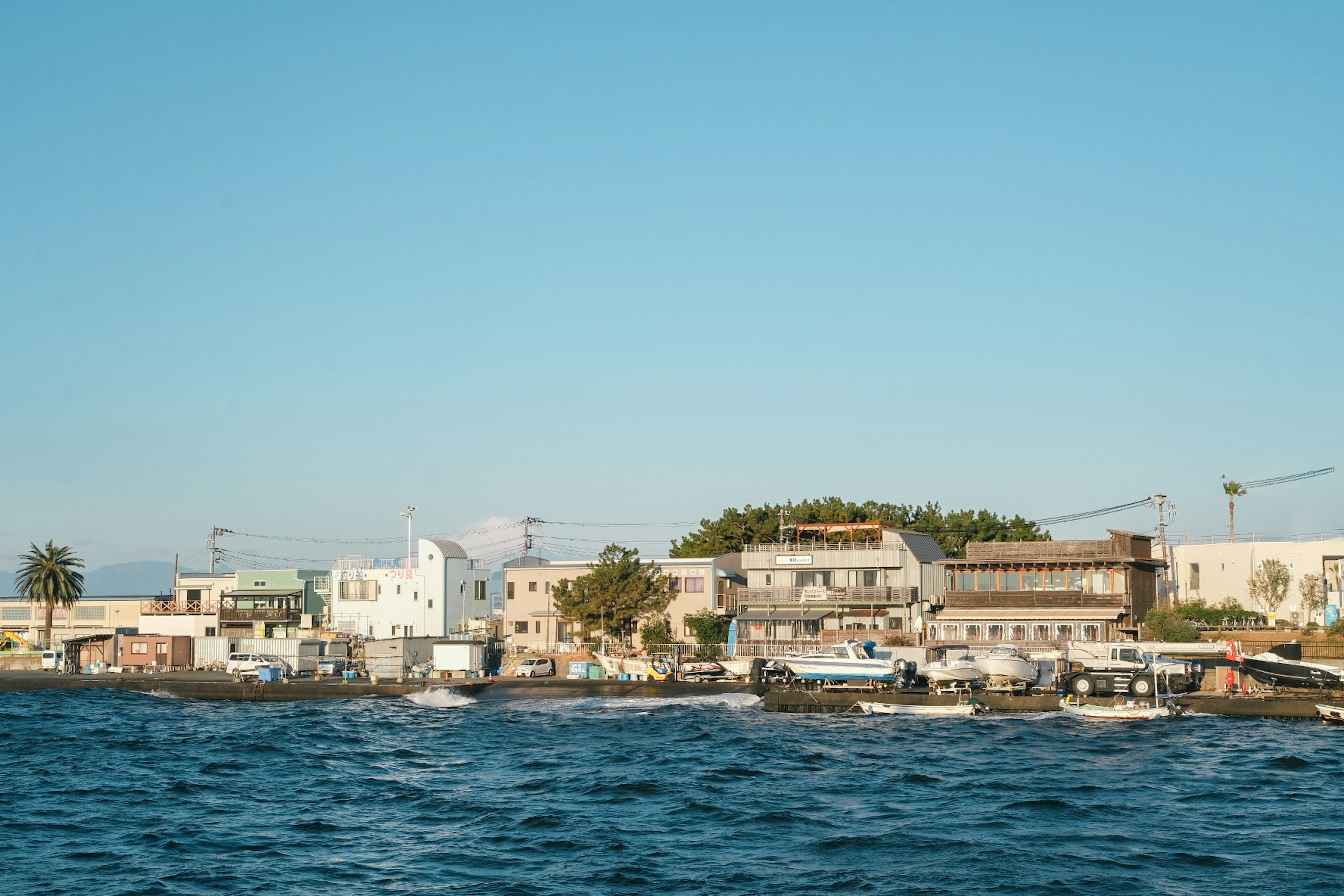 Scena costiera con edifici lungo la riva e cielo azzurro