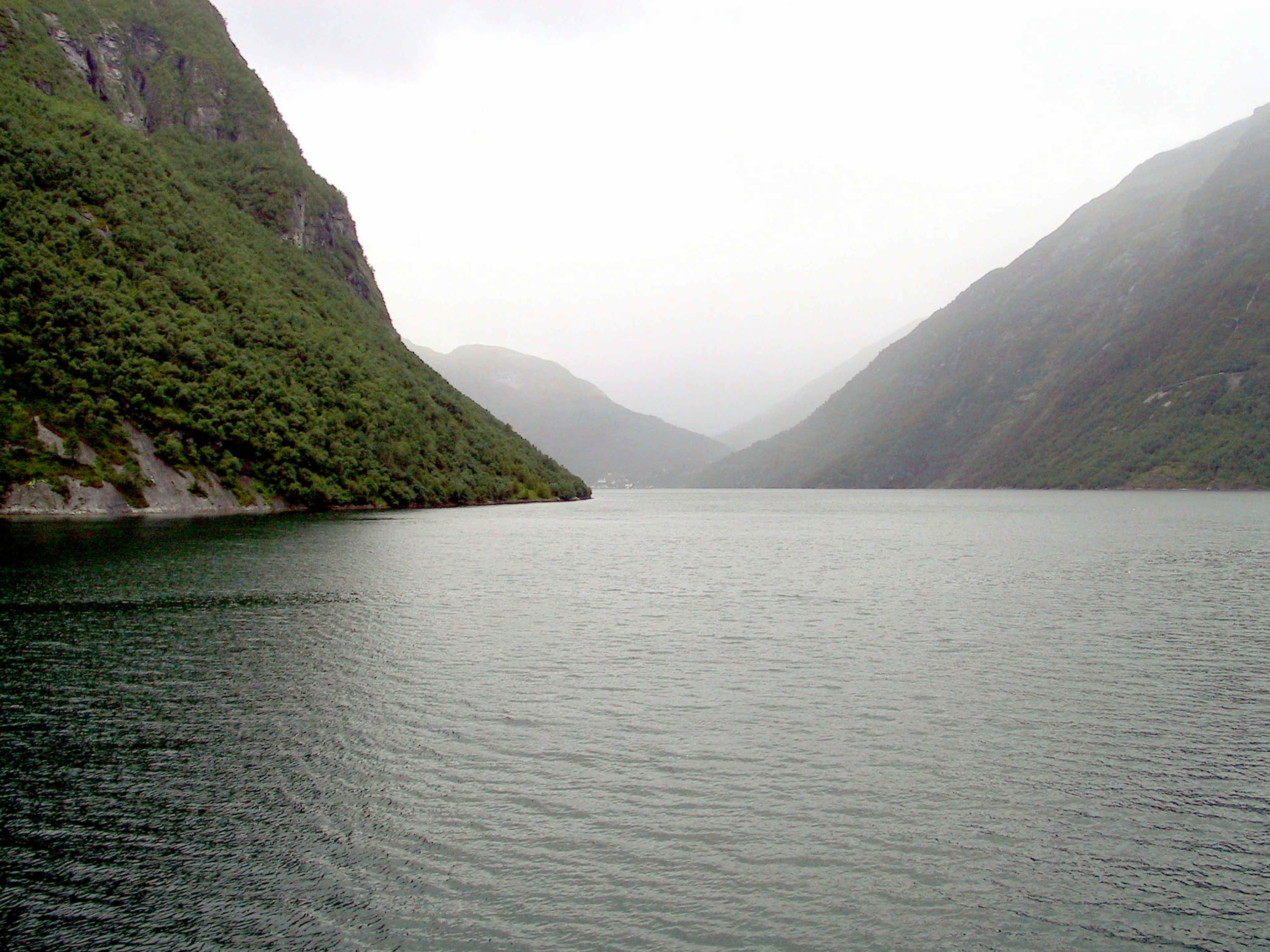 A serene lake surrounded by misty mountains