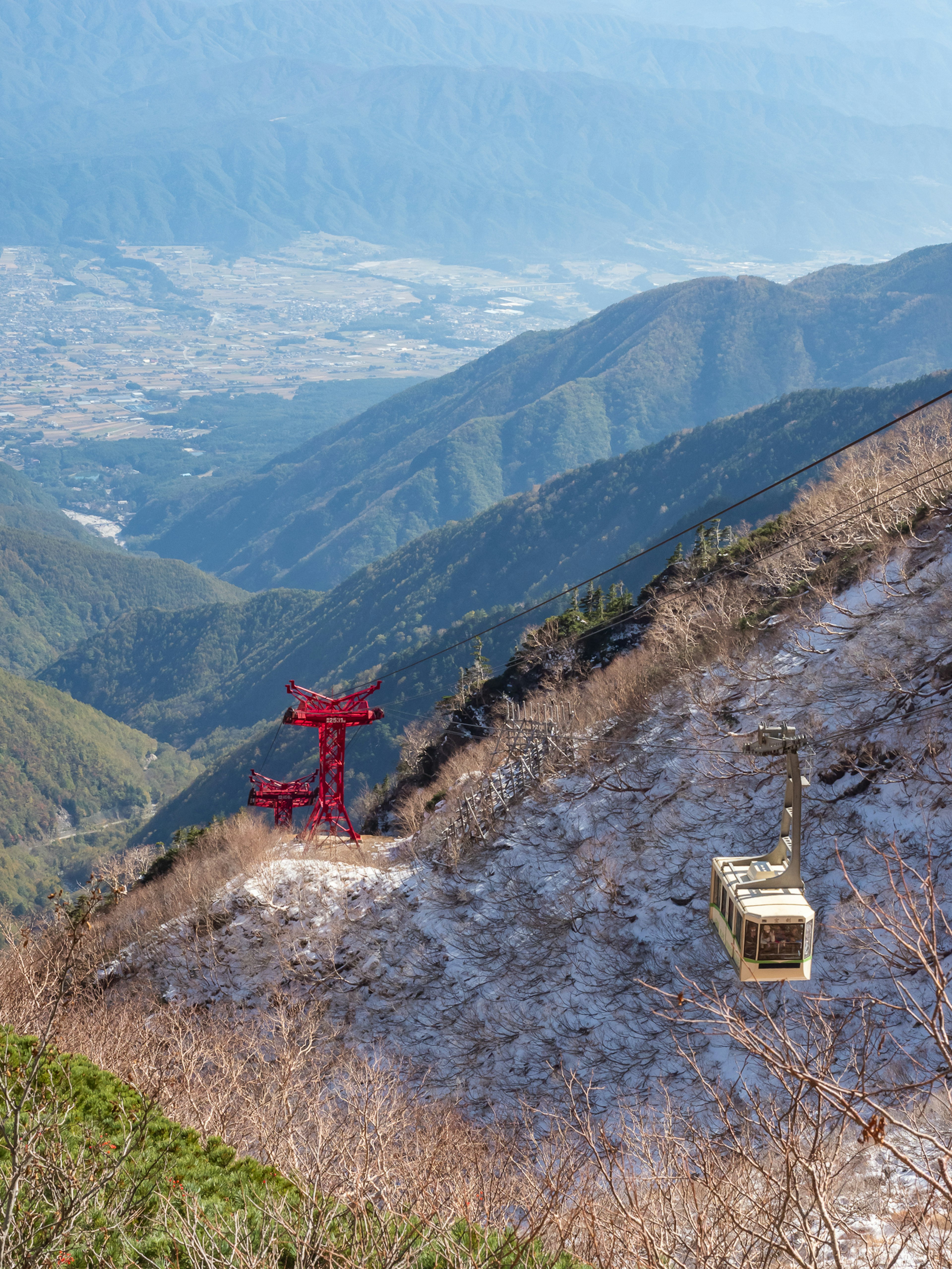 山の斜面にある二つのロープウェイと美しい景色