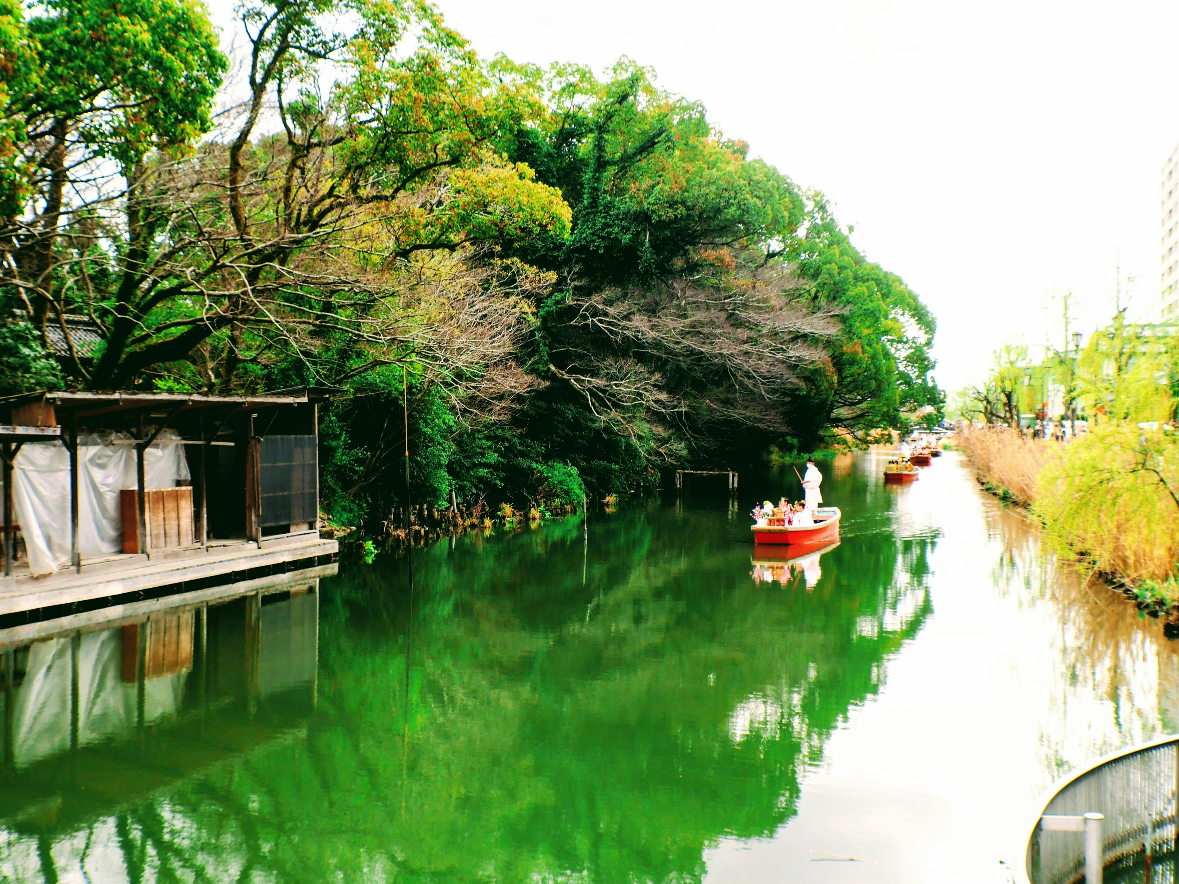 Canal serein entouré de verdure avec de petits bateaux sur l'eau