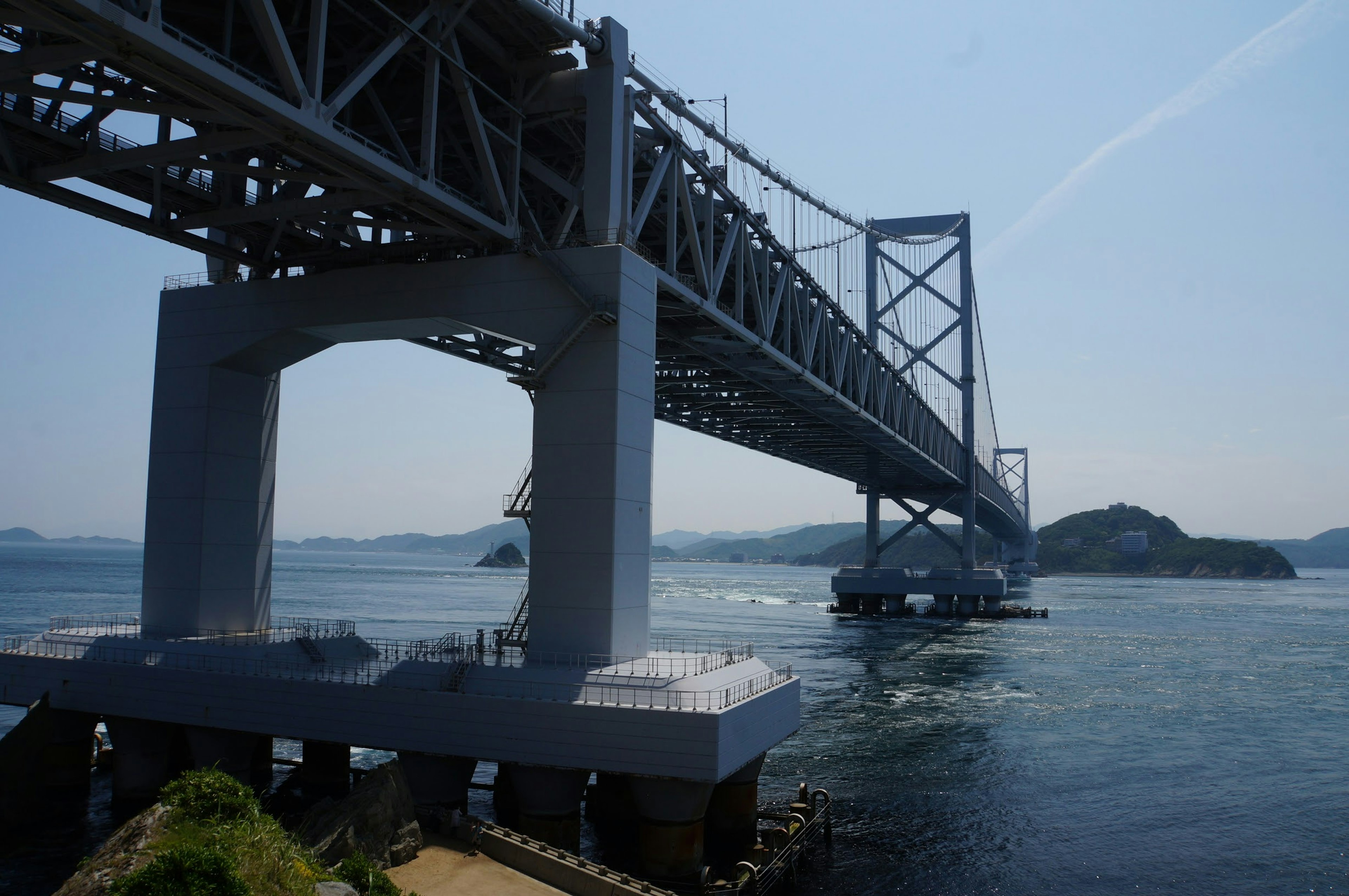 A large bridge spanning over water under a clear blue sky