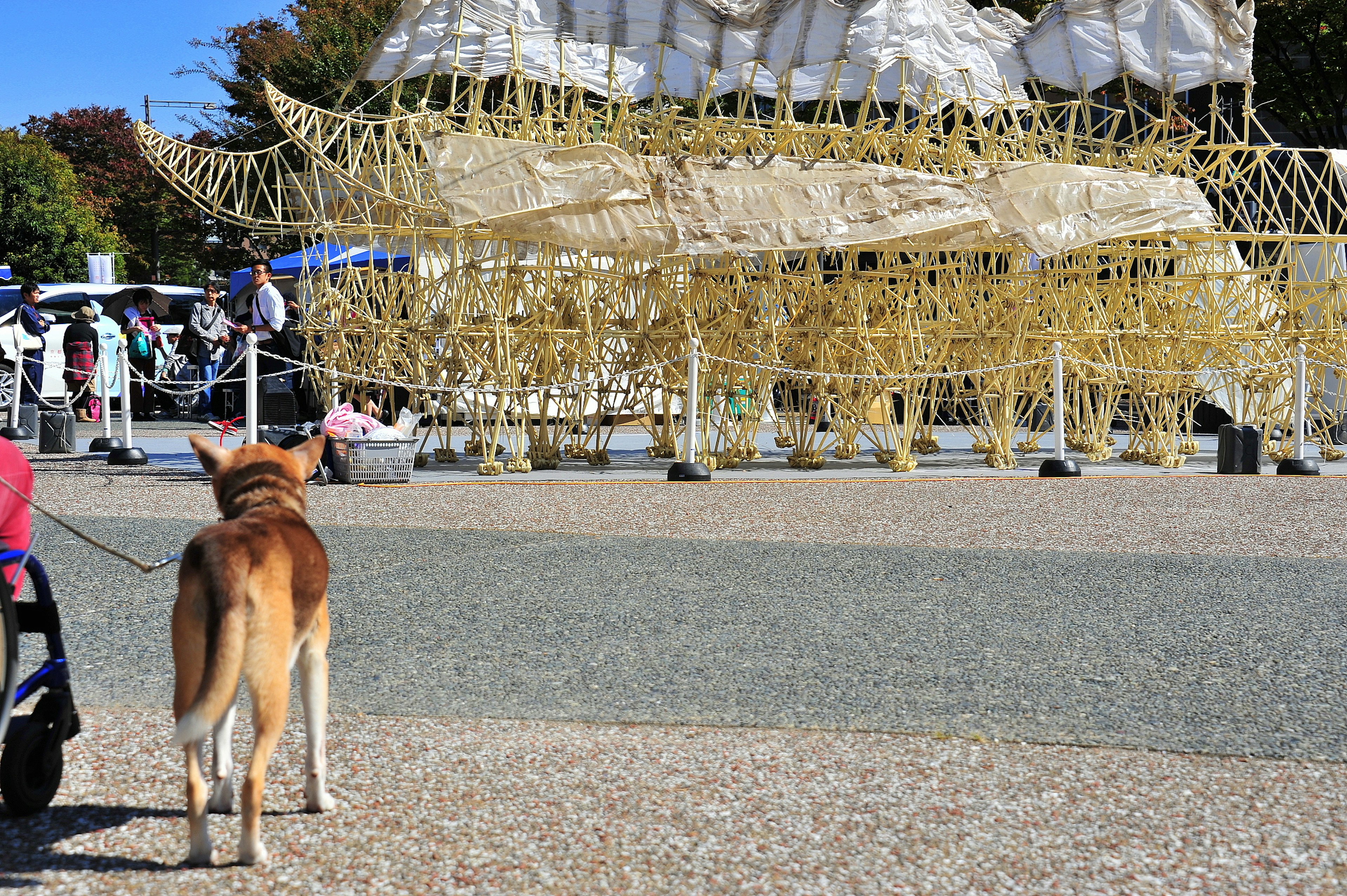 Un chien se tenant devant une grande sculpture