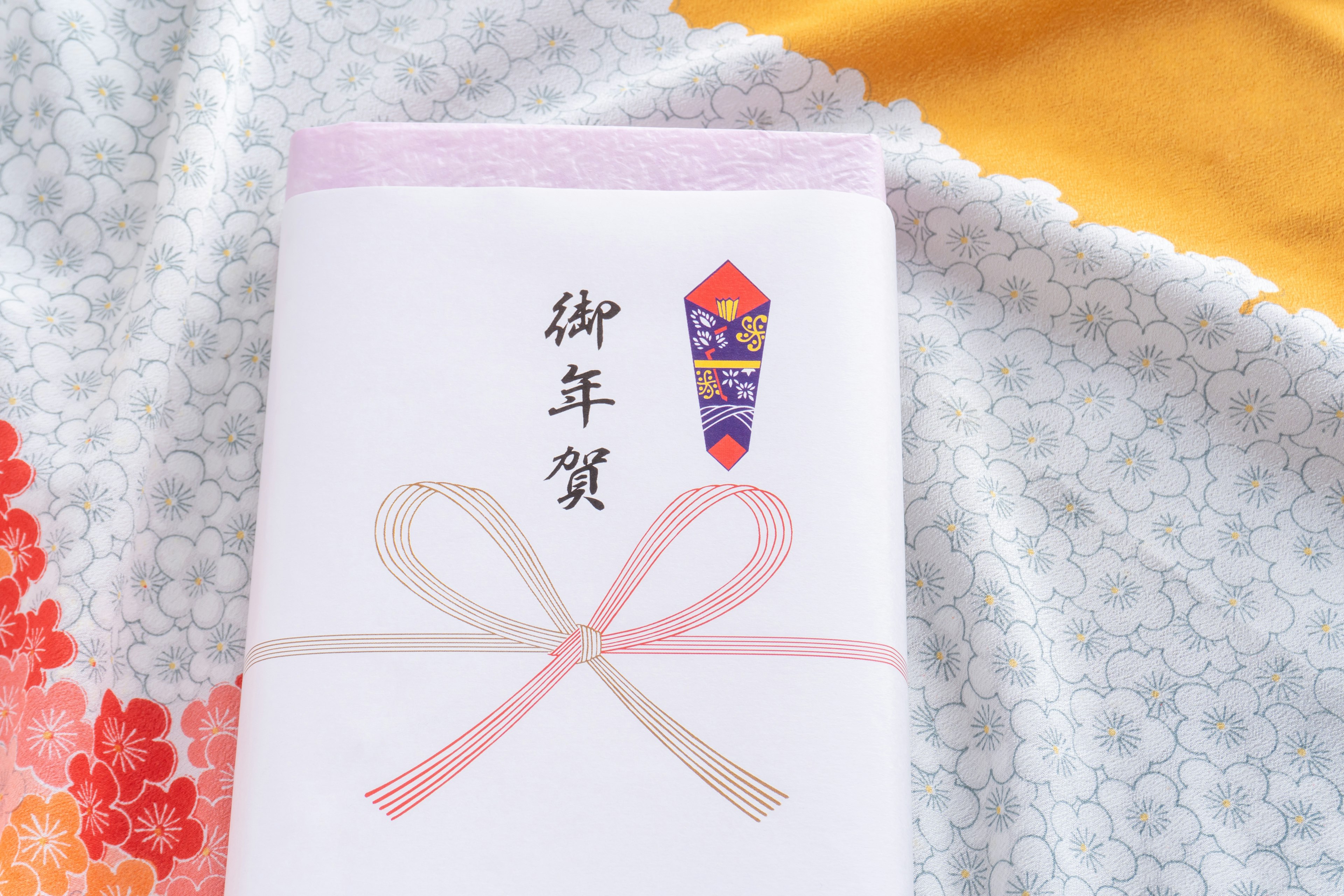 White envelope tied with a ribbon featuring a traditional Japanese New Year's money gift design