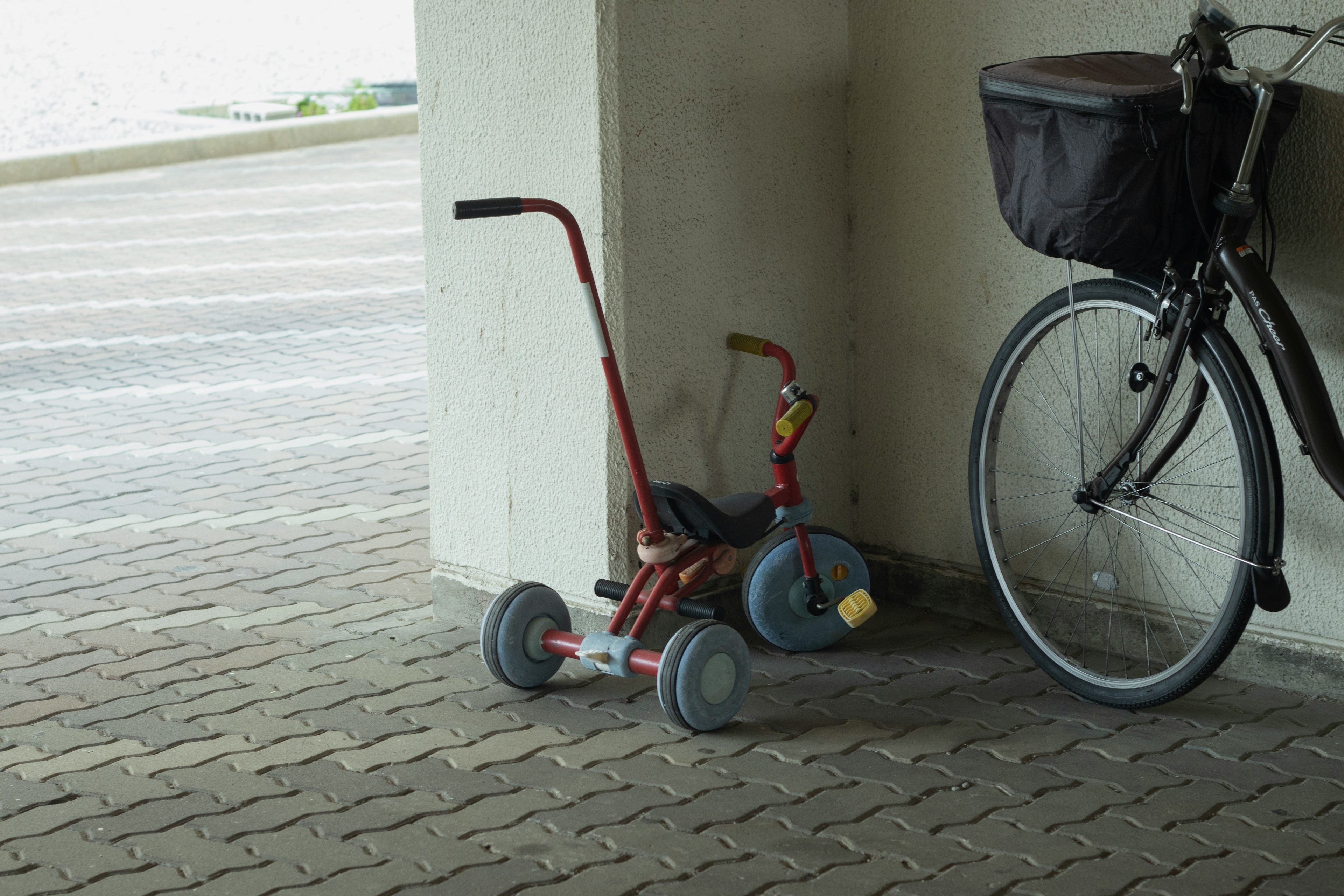 赤い三輪車と自転車が並んでいる風景