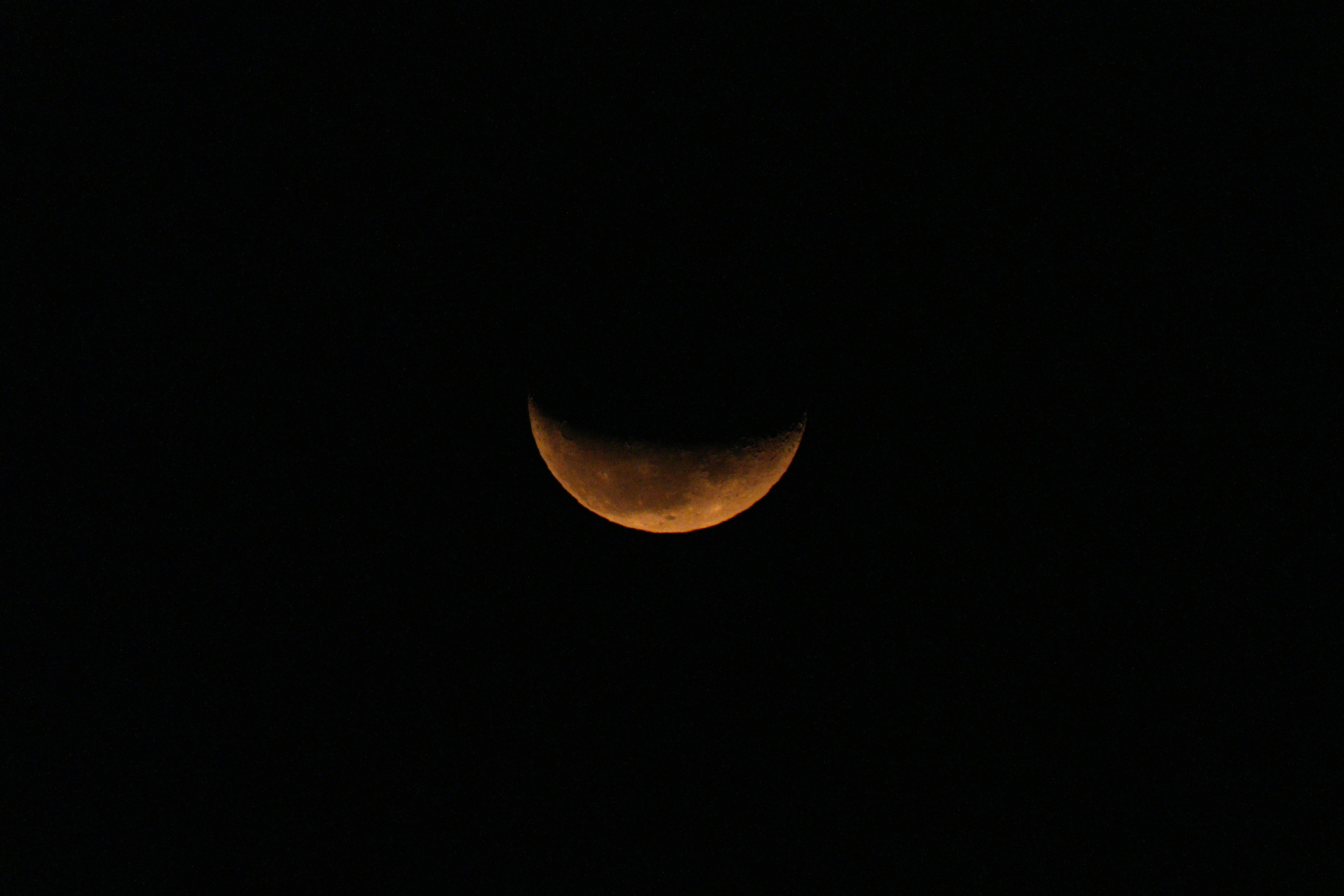 Bulan sabit oranye di langit malam