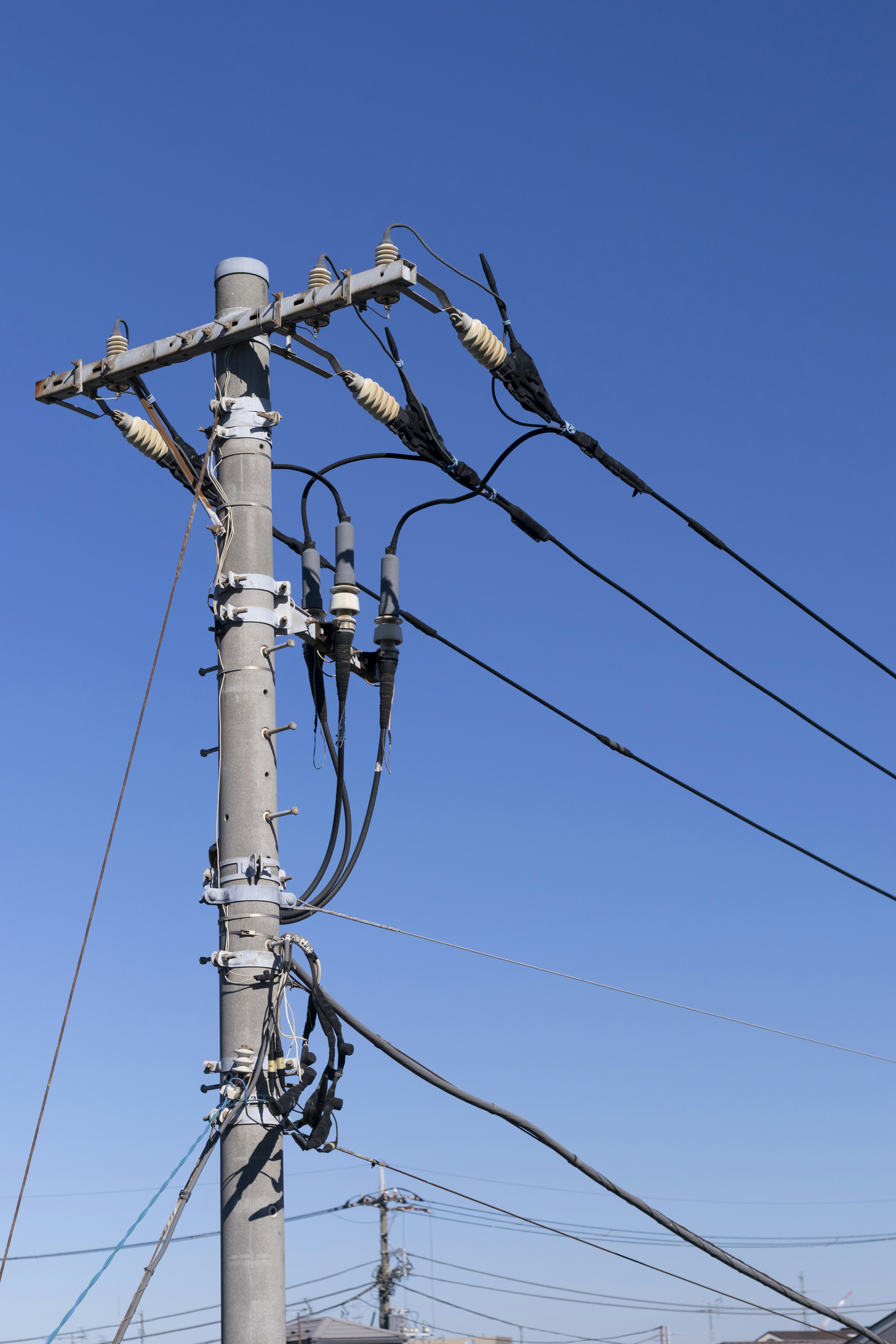 Utility pole with wires against a clear blue sky