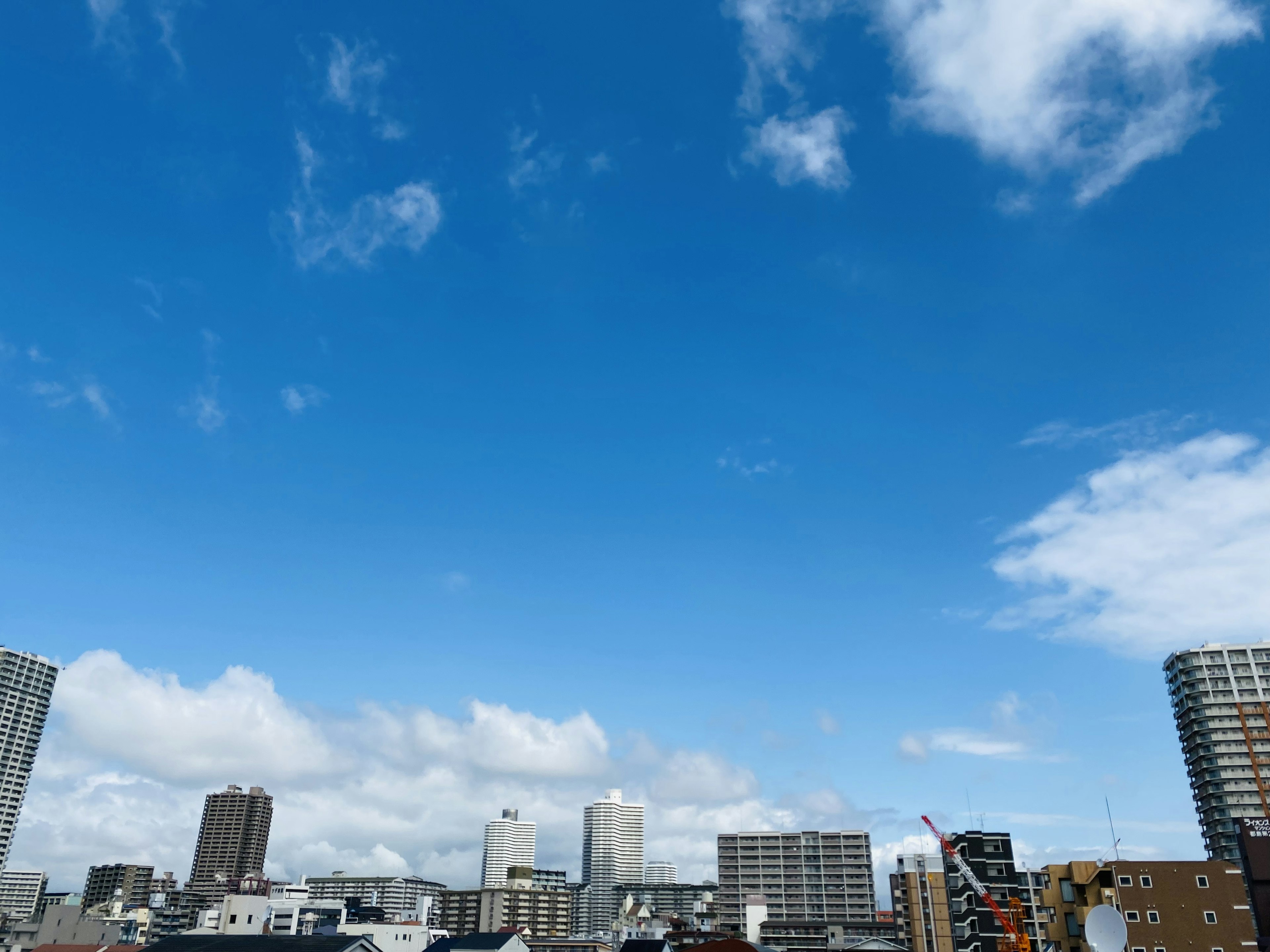 Ligne d'horizon de la ville avec un ciel bleu clair et des nuages épars