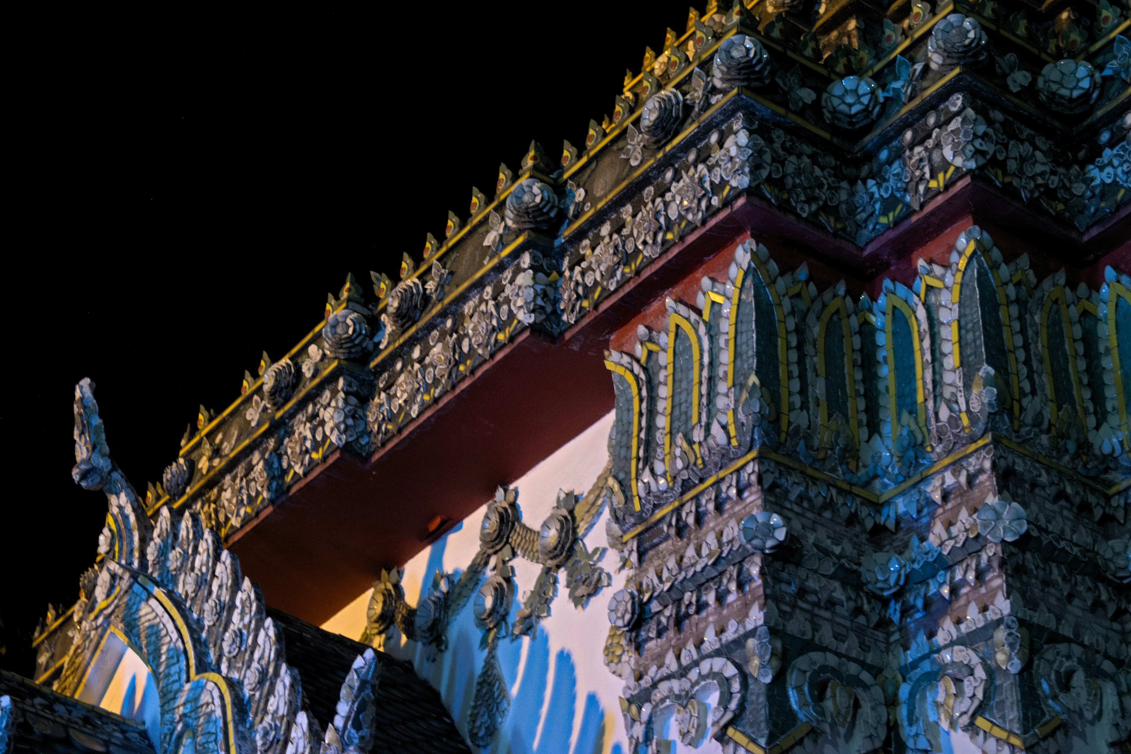 Detailed view of a temple roof with intricate carvings at night