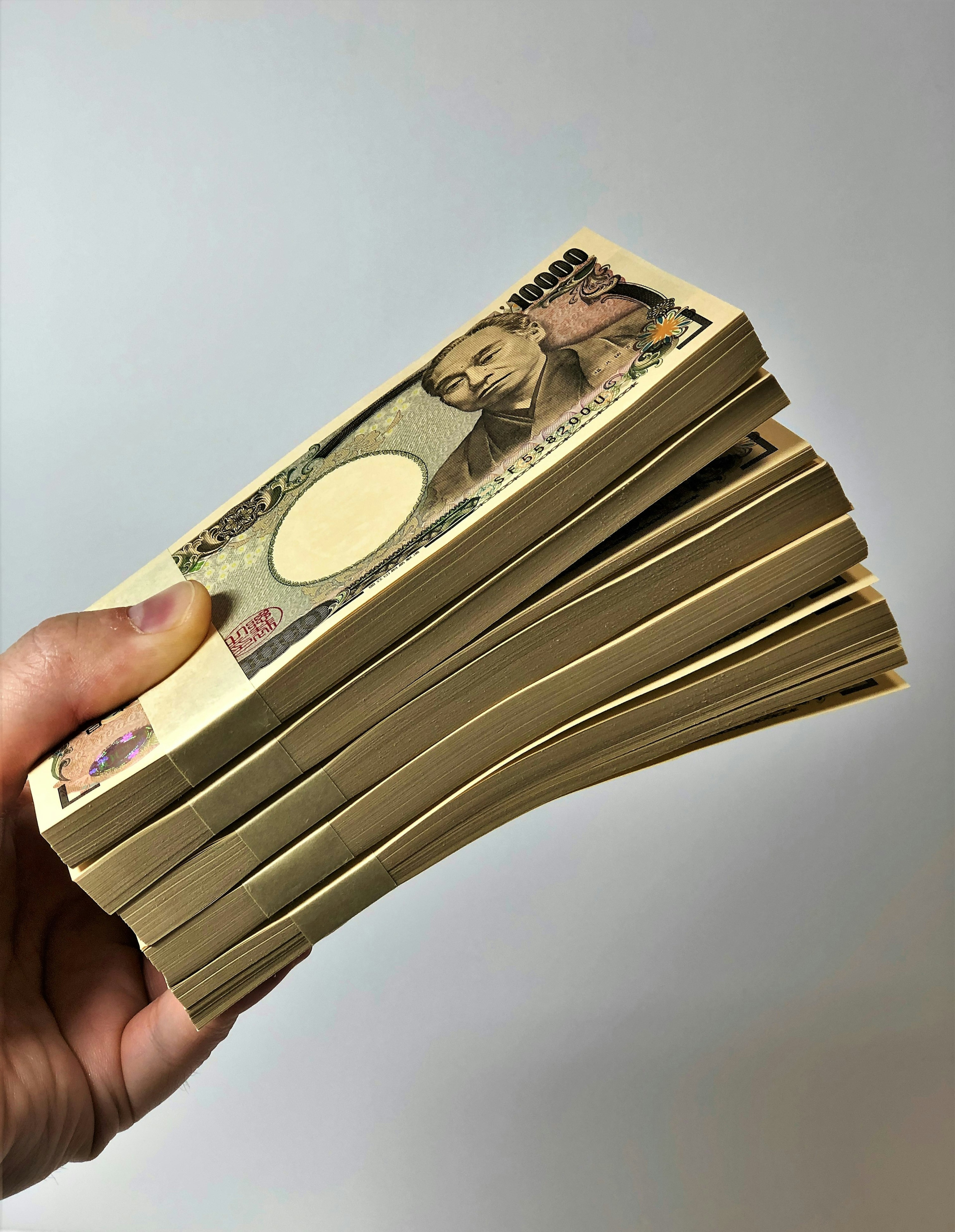 A stack of Japanese yen held in a hand