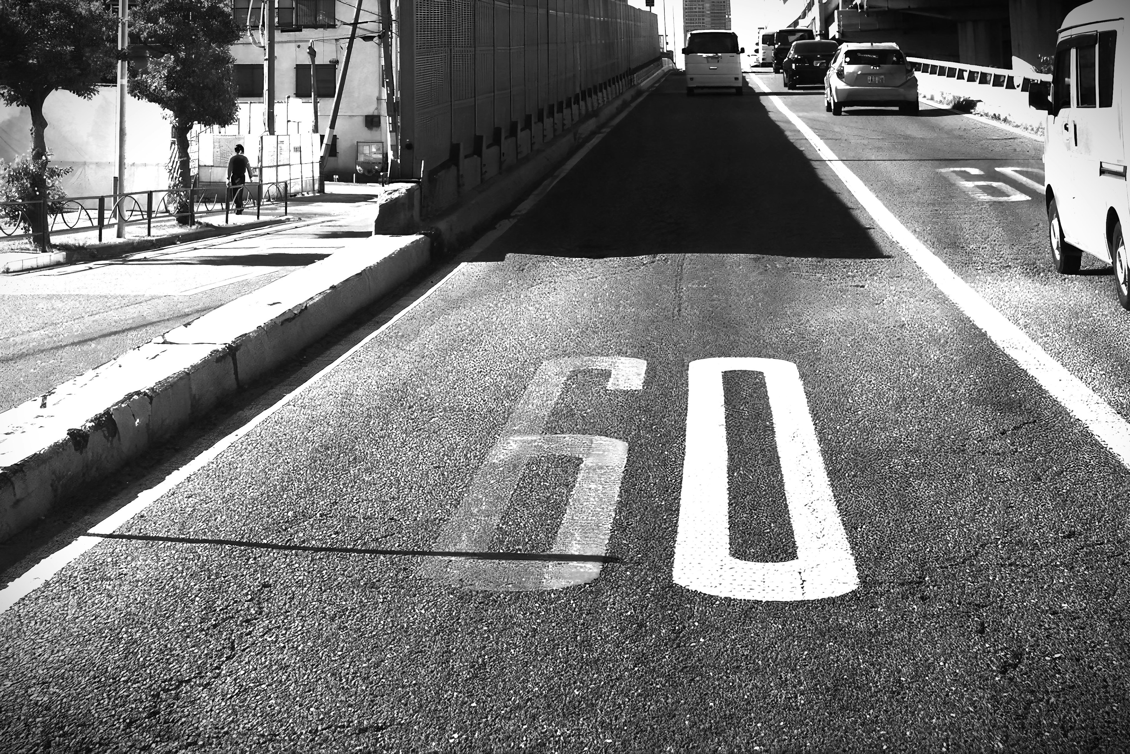 Scène routière avec un panneau de limitation de vitesse indiquant 60 et des véhicules visibles