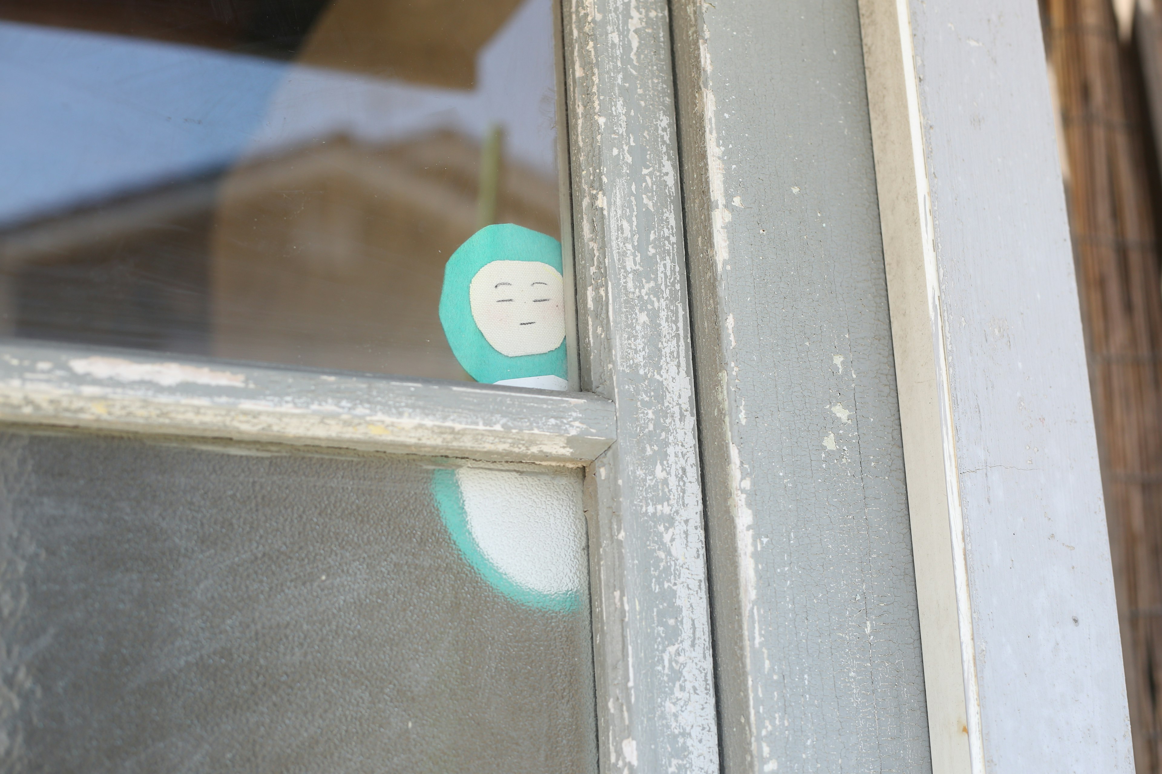 Close-up of a blue and white sticker on a window frame