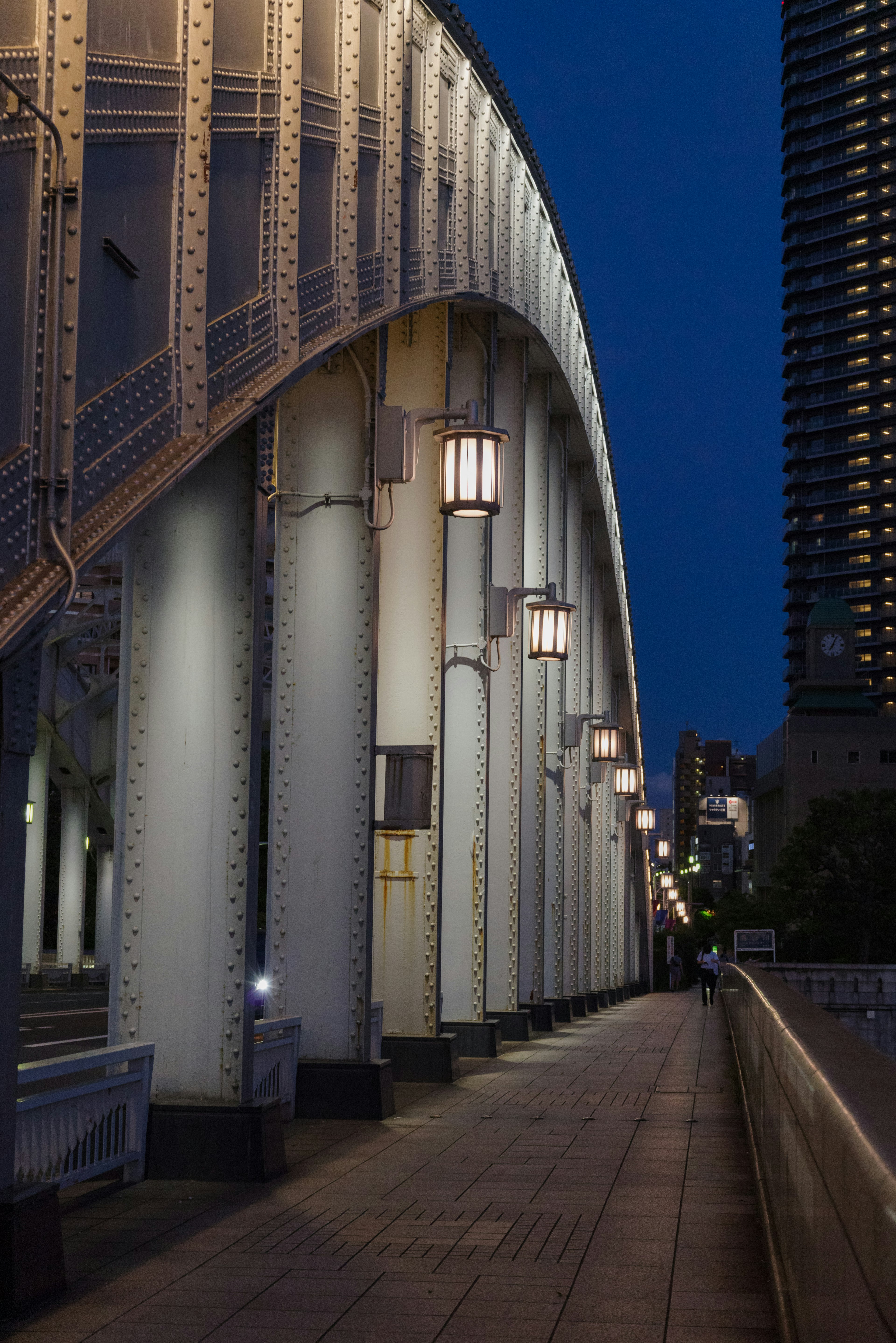 Arch bridge columns and streetlights illuminated at night