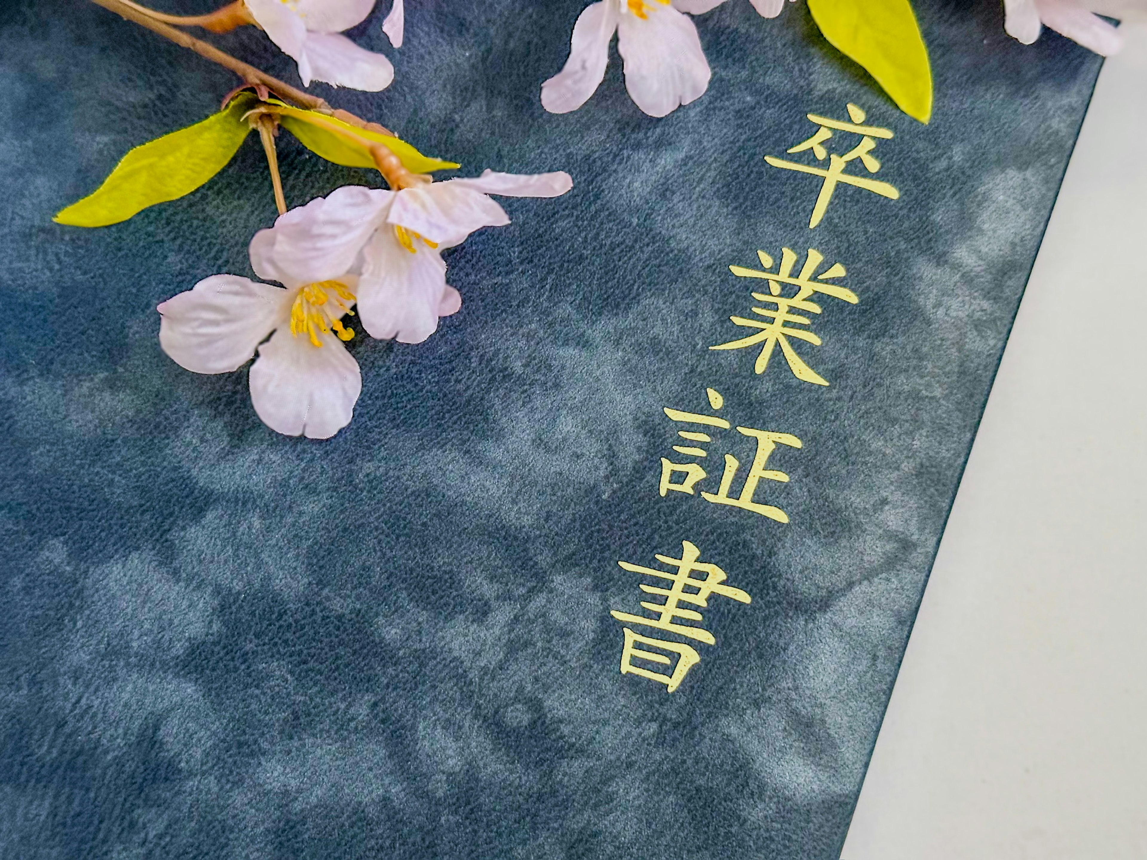 A blue background with cherry blossoms and the text for a graduation certificate