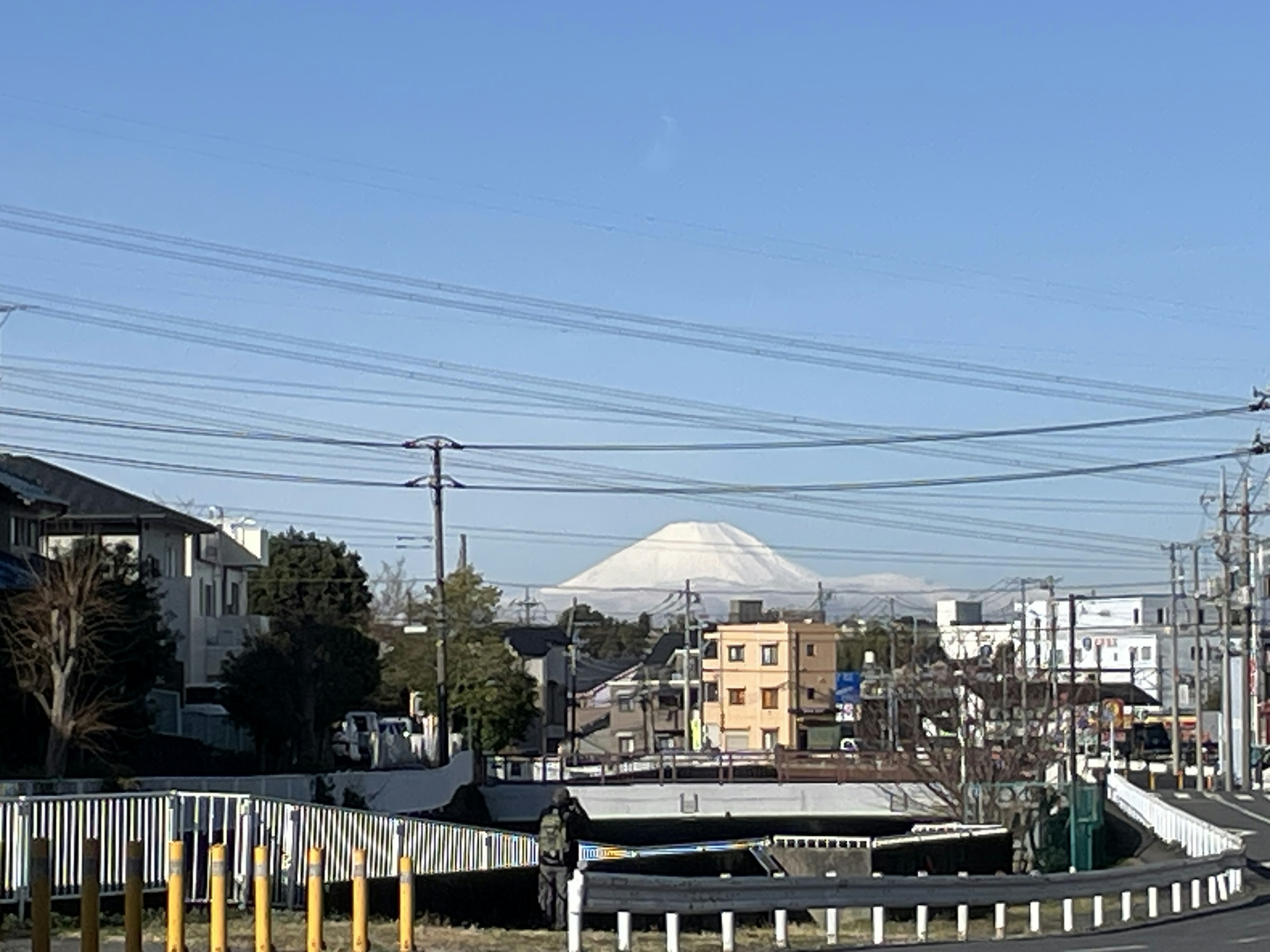 Malersicher Blick auf den Fuji unter einem klaren blauen Himmel mit umliegenden Gebäuden