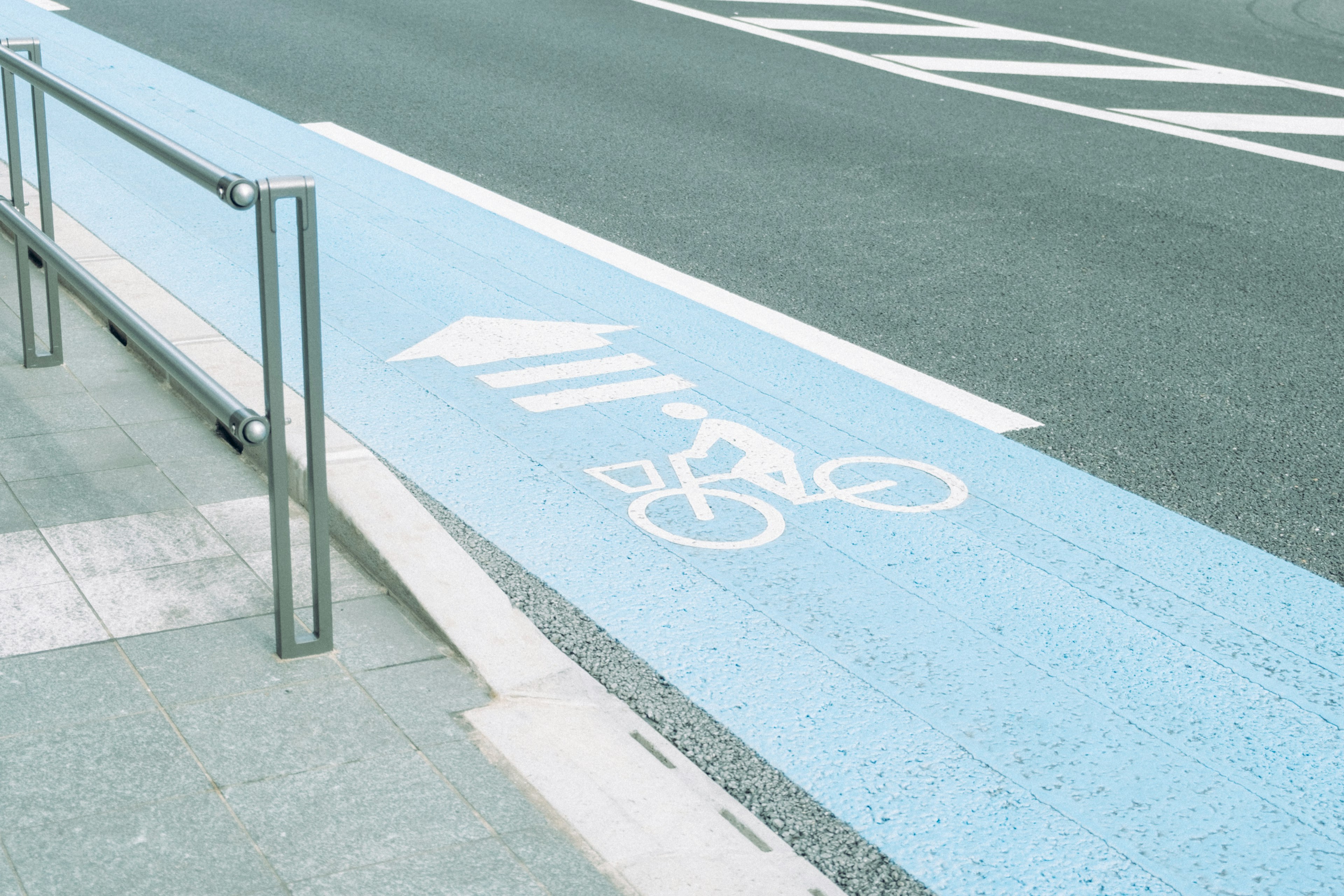 Corsia ciclabile blu con simbolo di bicicletta dipinto sulla strada