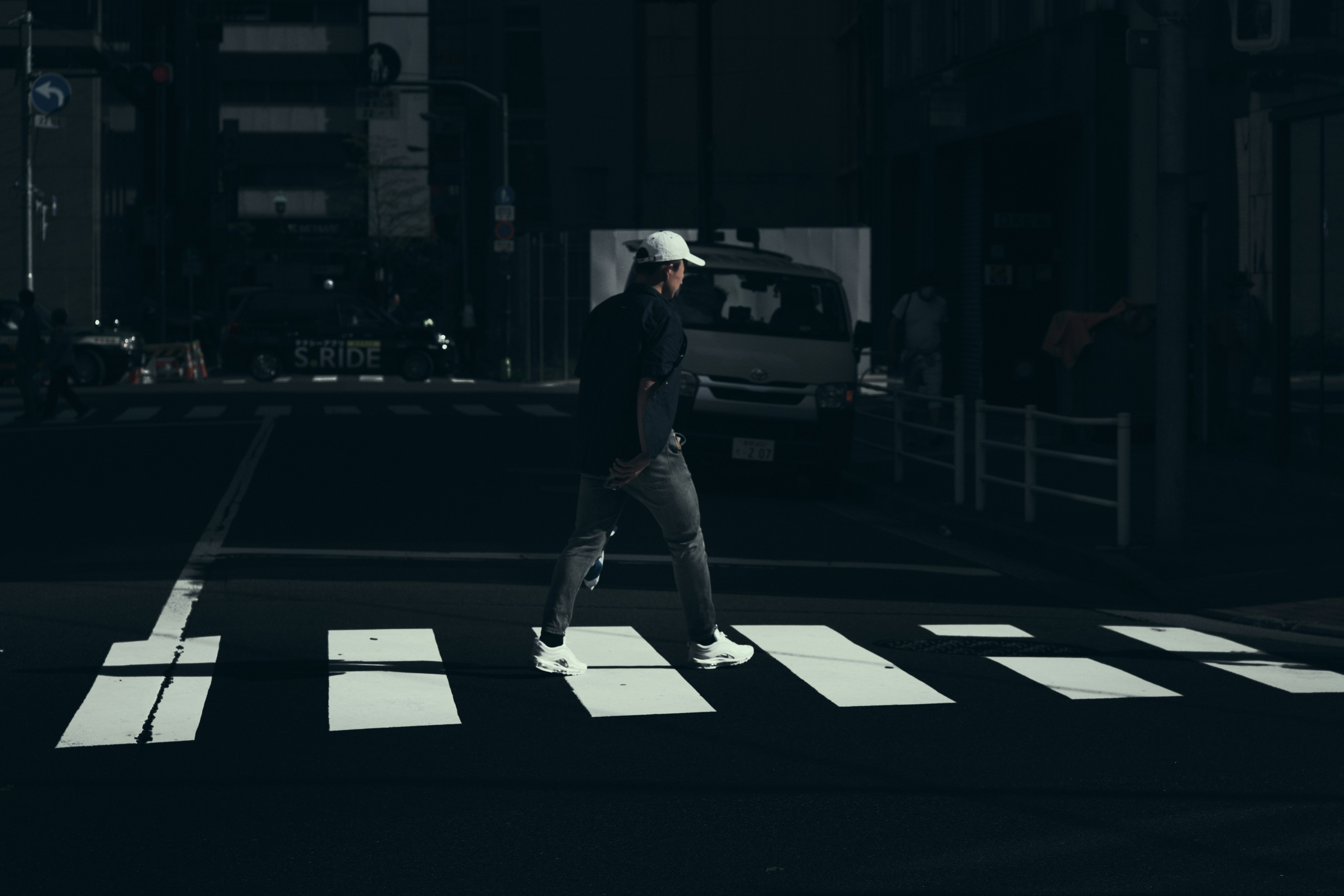 暗い通りで横断歩道を渡る人