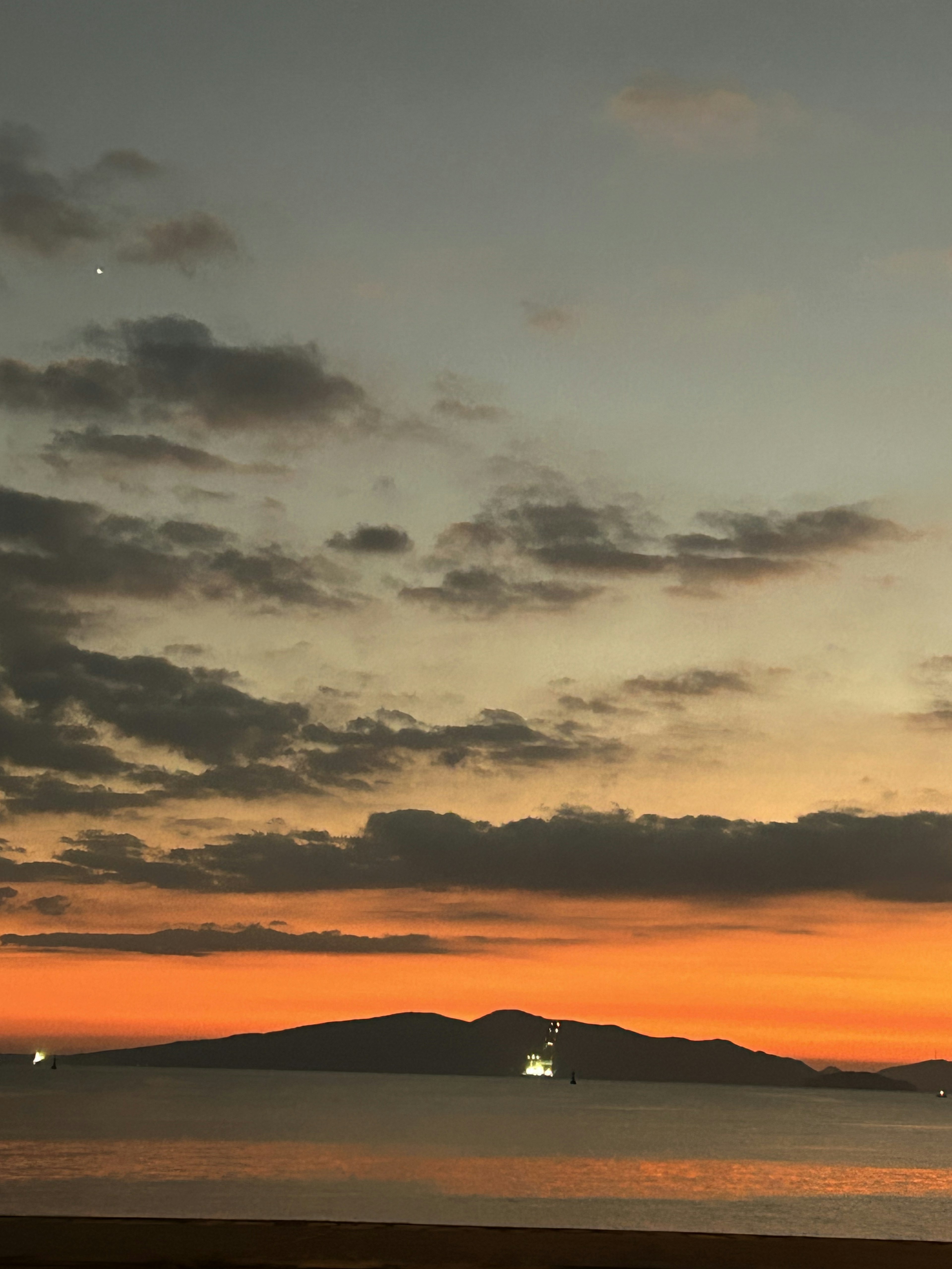 夕焼けの空と静かな海に浮かぶ島の景色