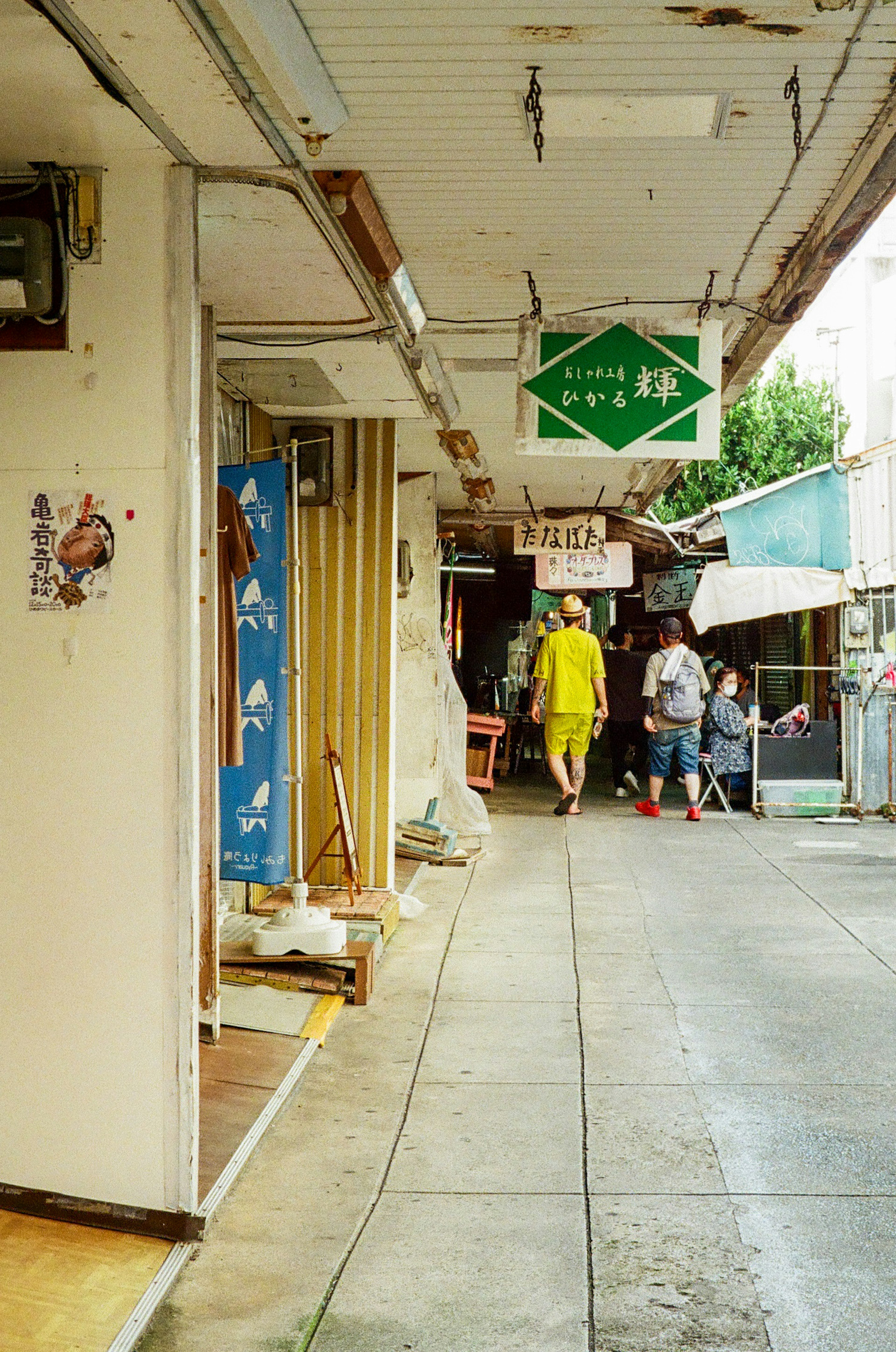 狭い通りに沿った店舗と人々の姿が見える