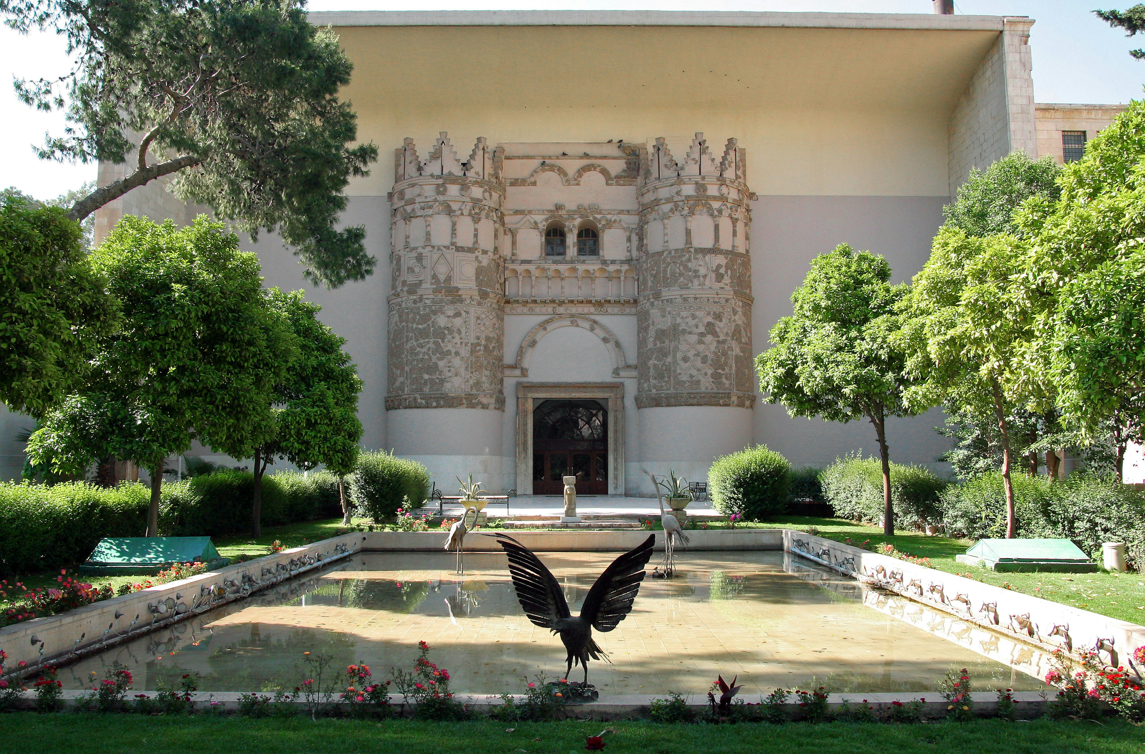 Fachada de un edificio histórico rodeado de un hermoso jardín y un estanque