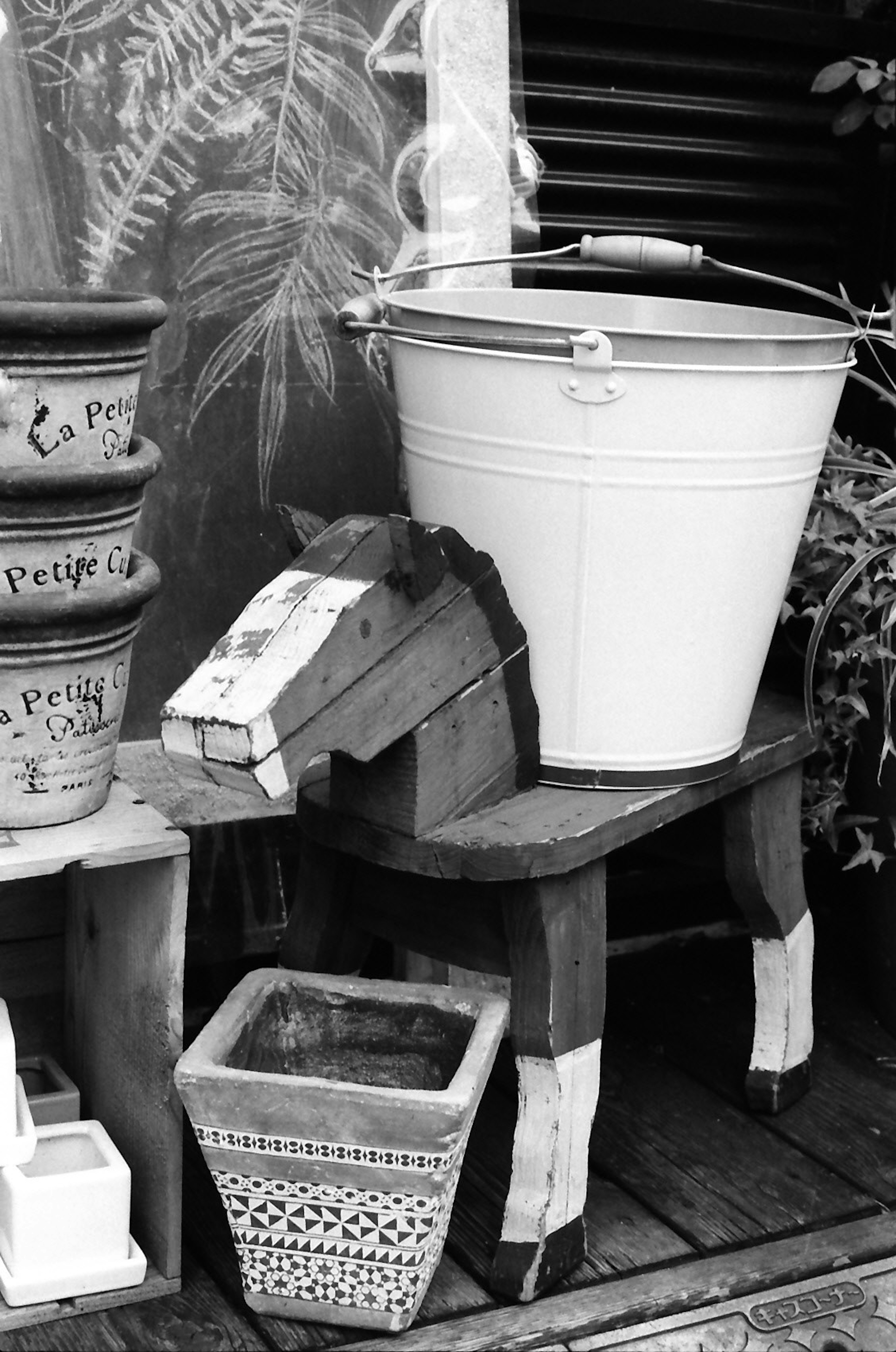 Image of a white bucket and a wooden horse sculpture on a table