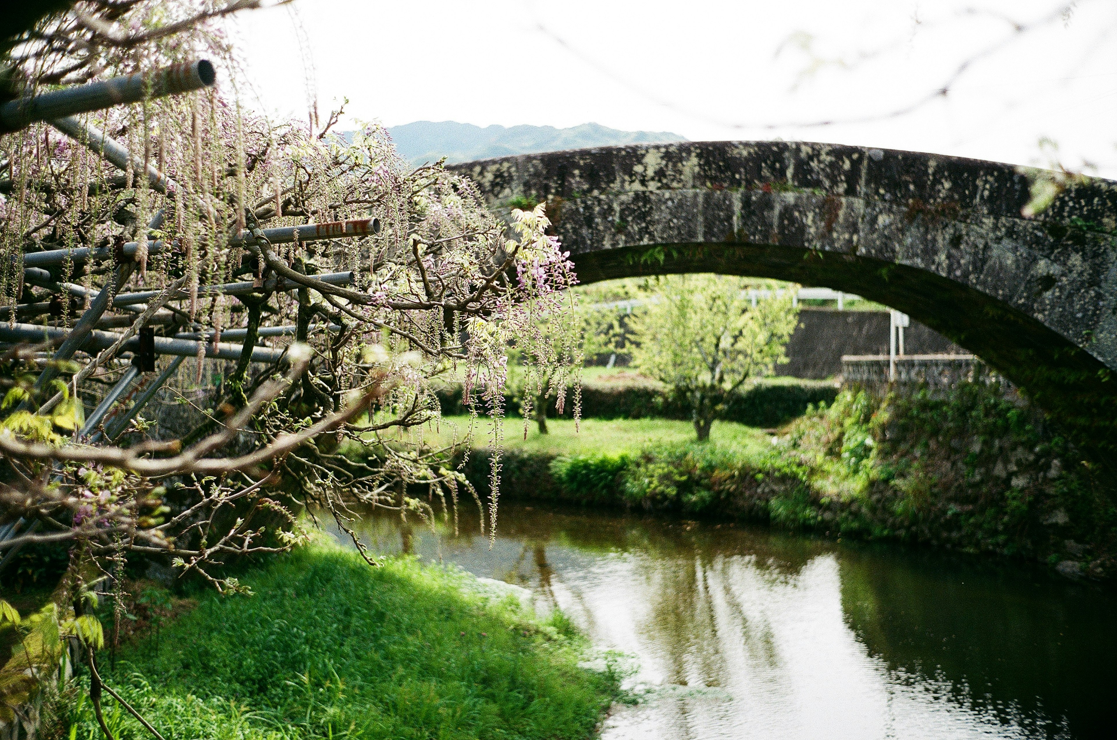 Scenic view of a stone arch bridge over a tranquil river