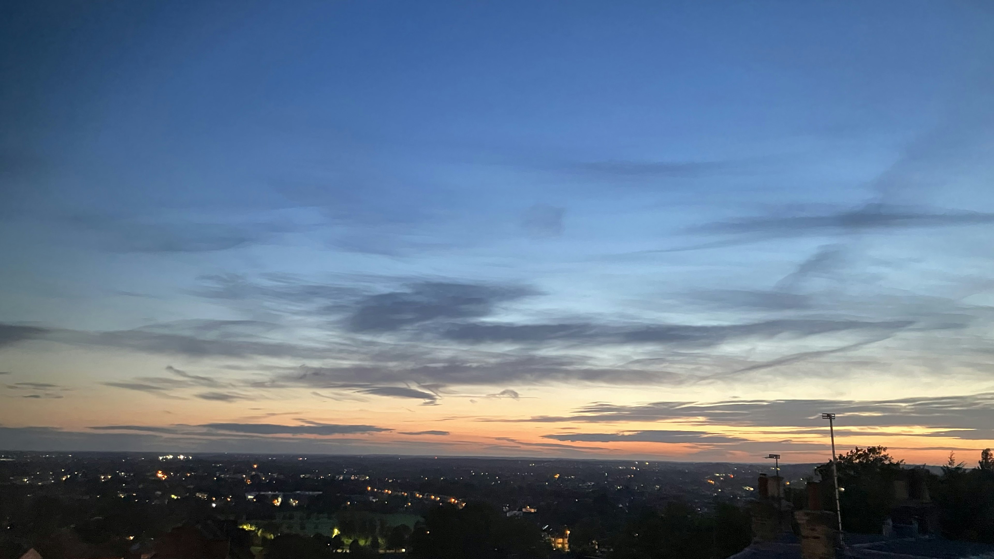 夕暮れの美しい風景 明るいオレンジと青の空 町の明かりが点在