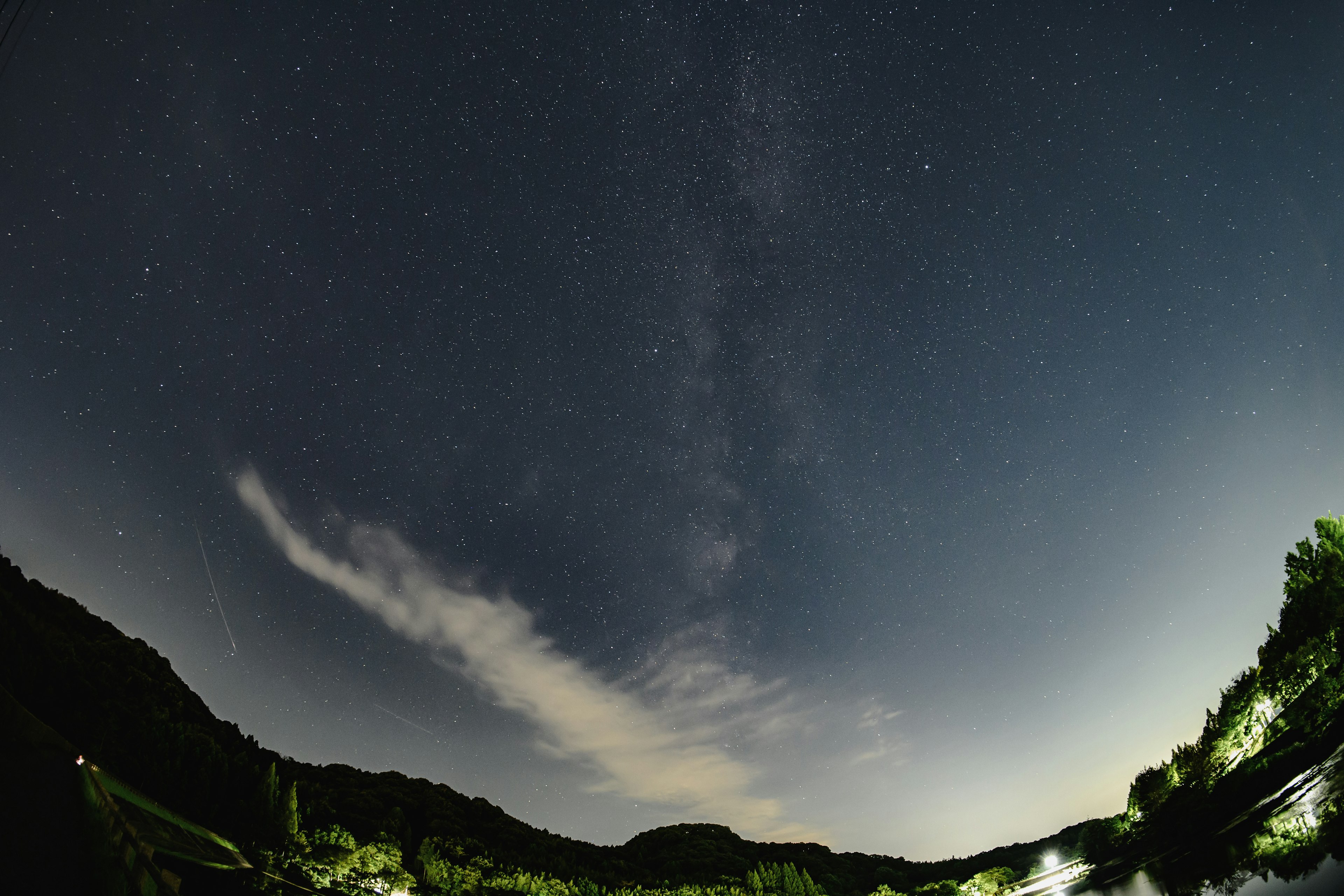 Langit malam dengan bintang dan awan di atas gunung