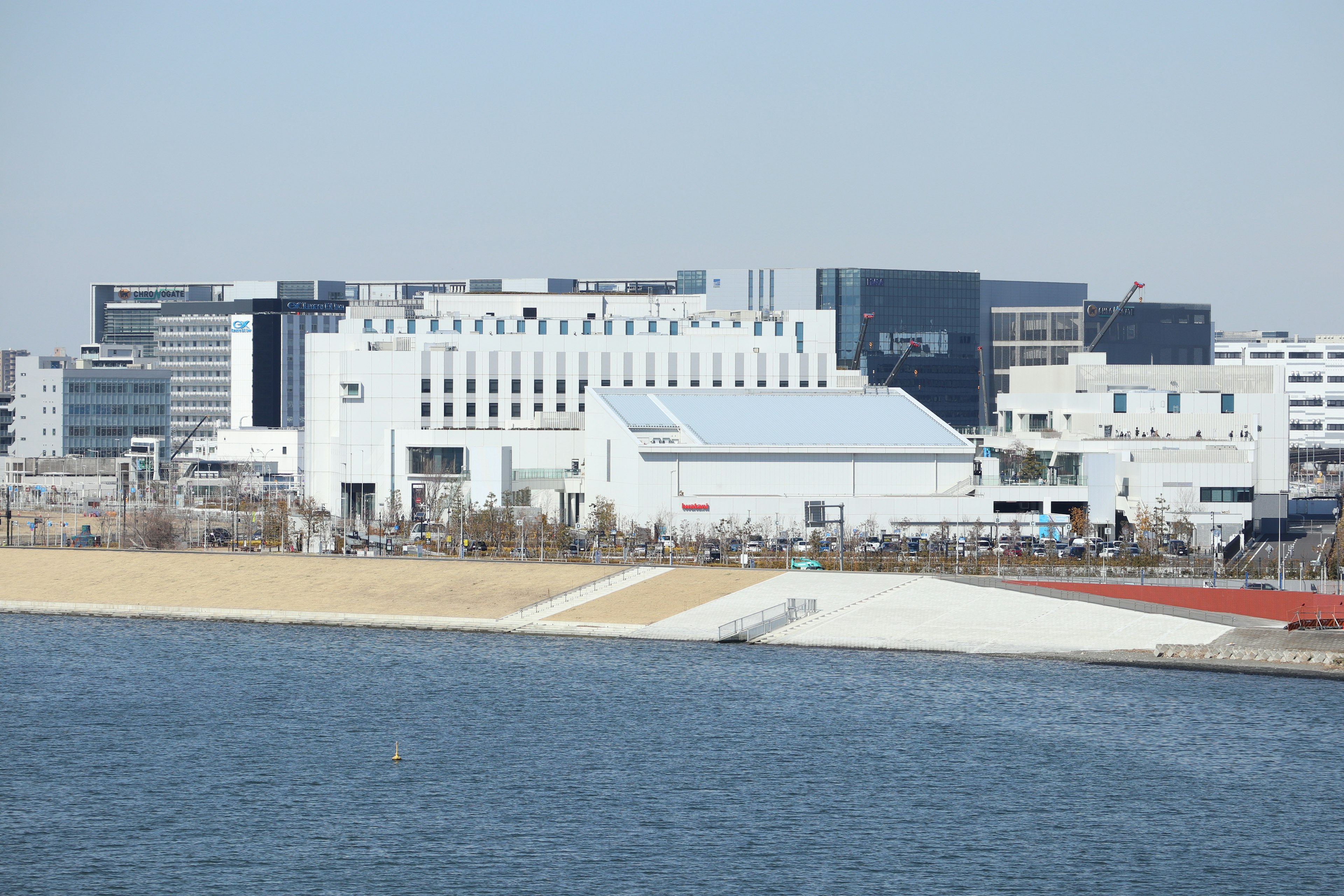 Modern buildings along the waterfront with a calm water surface