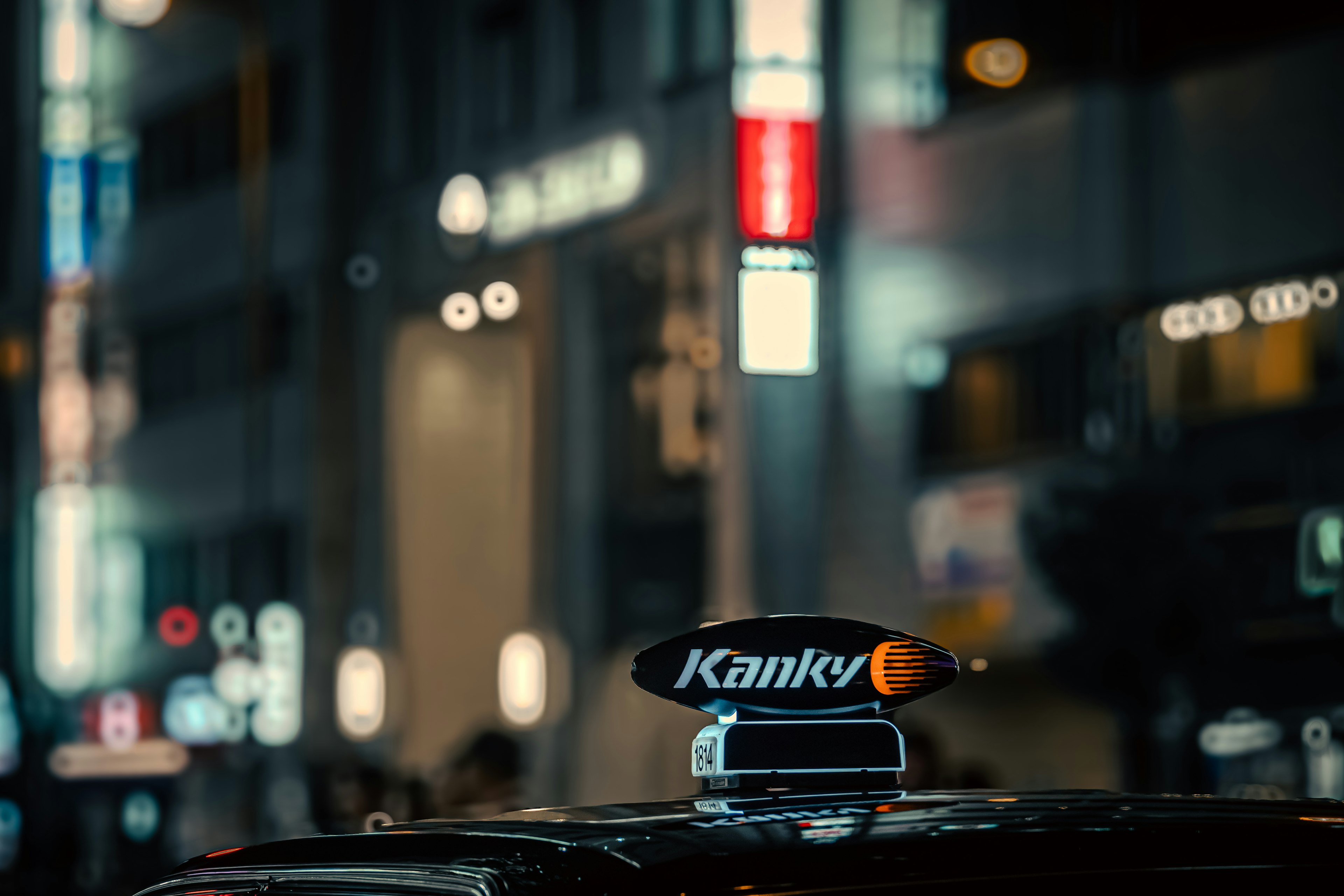 Taxi sign reading Kanky in a nighttime urban setting