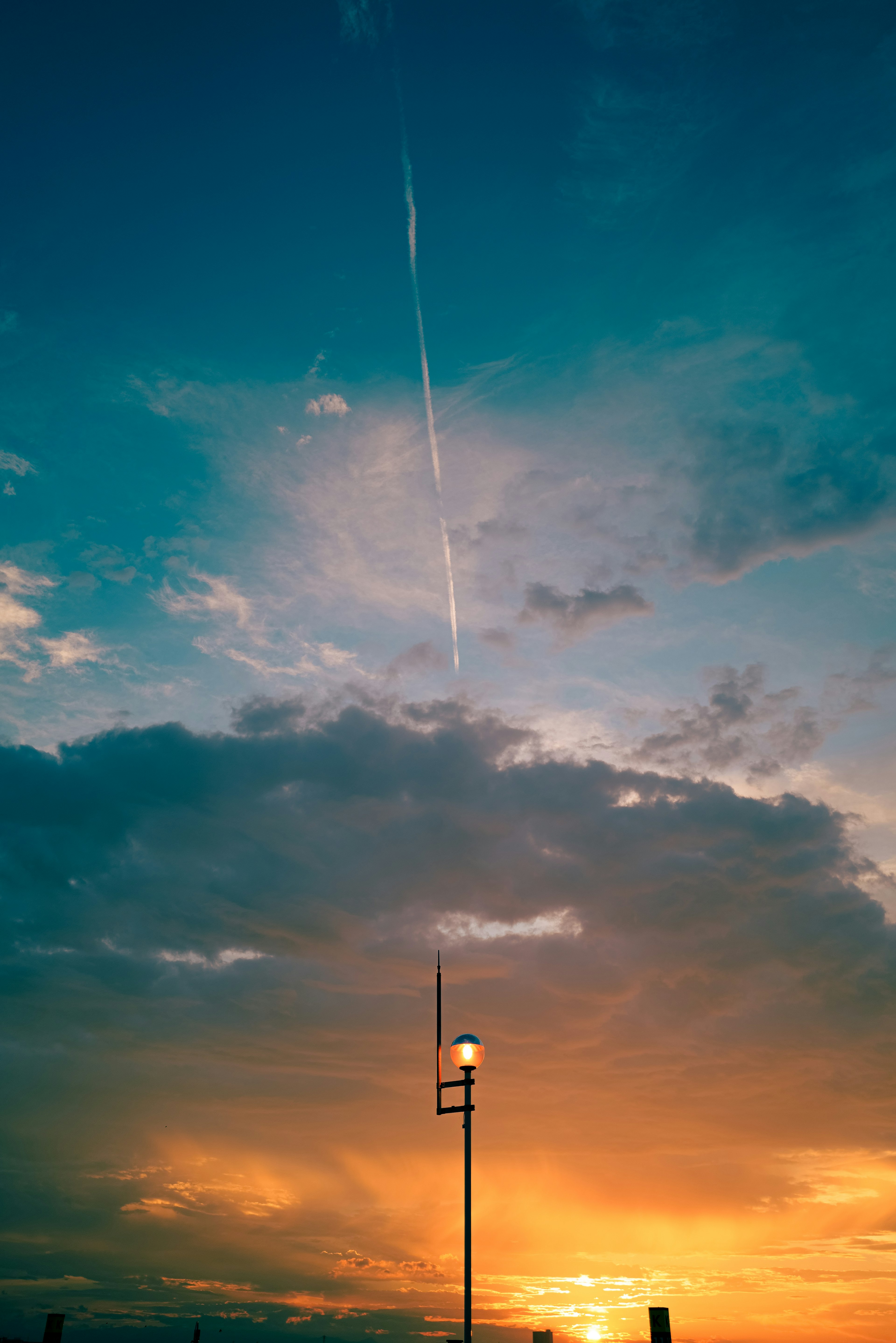 Hermoso cielo de atardecer con una torre en silueta contra tonos naranjas y azules