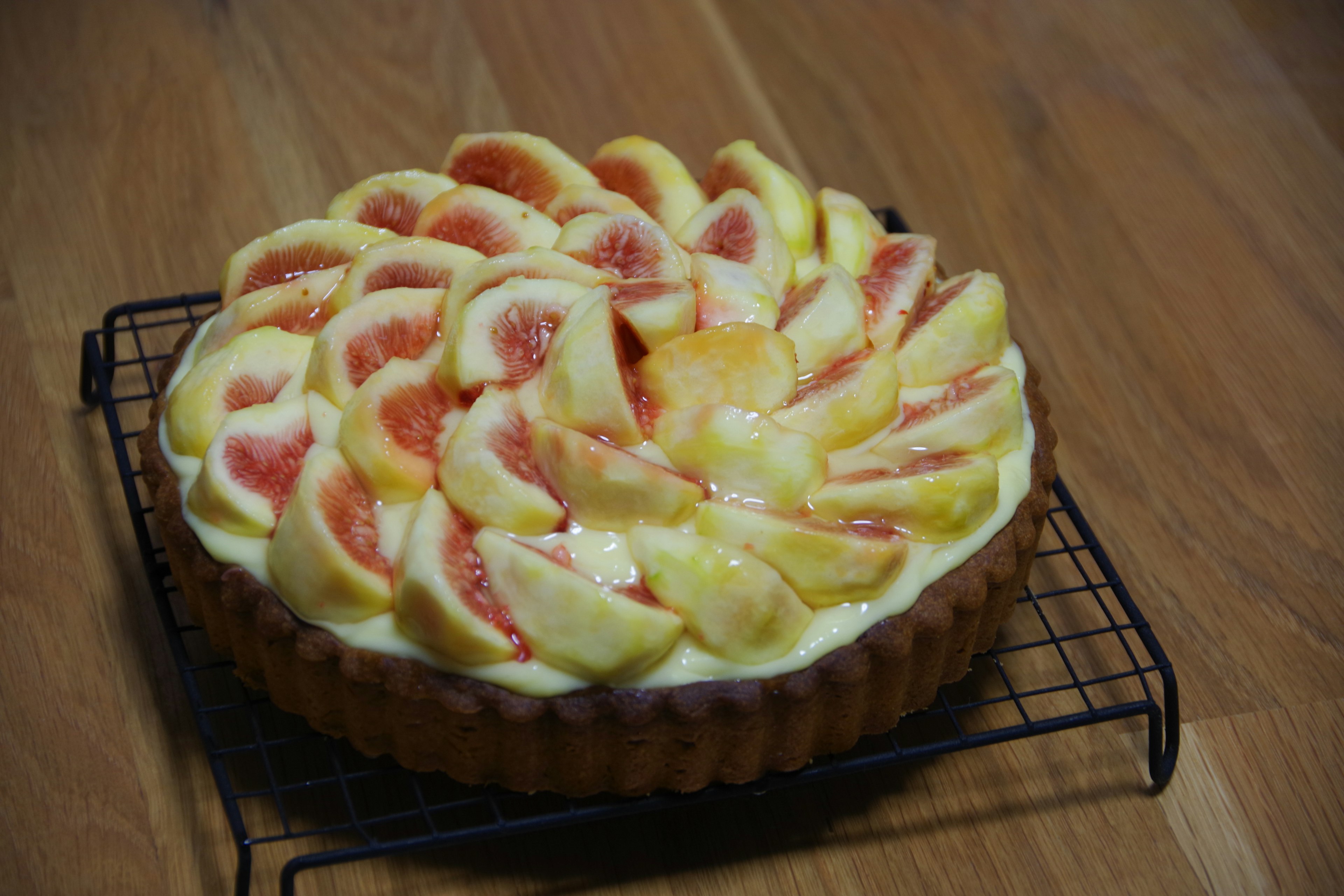 A beautiful fruit tart placed on a cooling rack